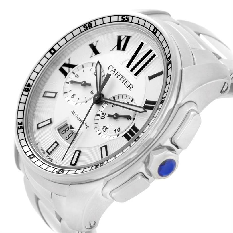 The image shows a close-up side angle of the Cartier Calibre de Cartier W7100045 Men's Stainless Steel Silver Dial W7100045 Men's Stainless Steel Silver Dial watch, highlighting its bezel, dial, and crown with a blue gemstone.