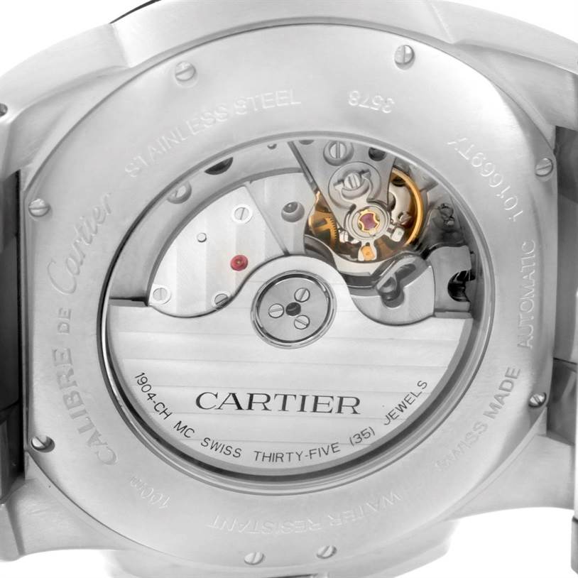 The image shows the back view of the Calibre de Cartier watch by Cartier, revealing the inner mechanism and engravings.