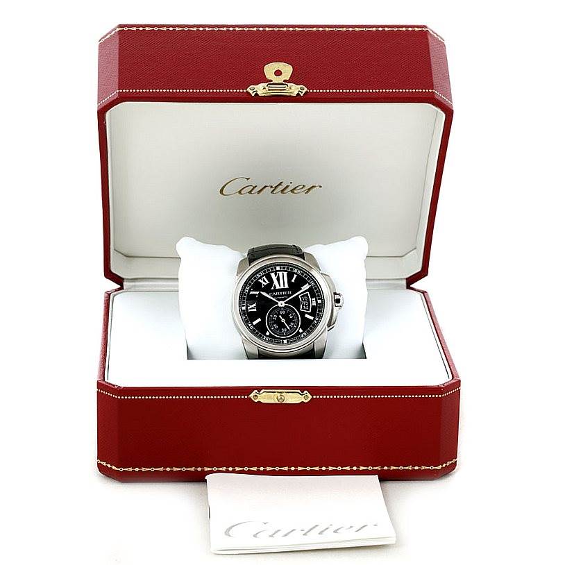 The Calibre de Cartier watch by Cartier is shown front-facing in an open red and white Cartier box.