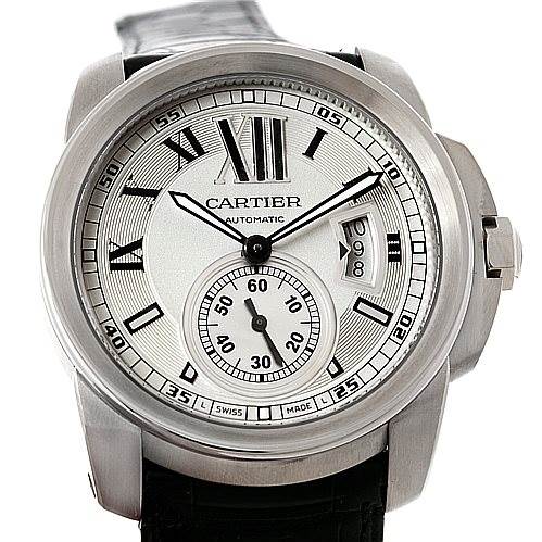 The image shows a front view of the Calibre de Cartier watch by Cartier, highlighting the dial, hour markers, hands, and date window.