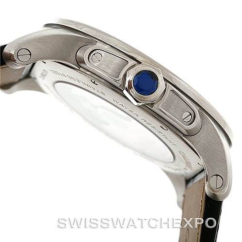 This image shows a side view of the Calibre de Cartier watch by Cartier, highlighting the crown with a blue gem and part of the case.