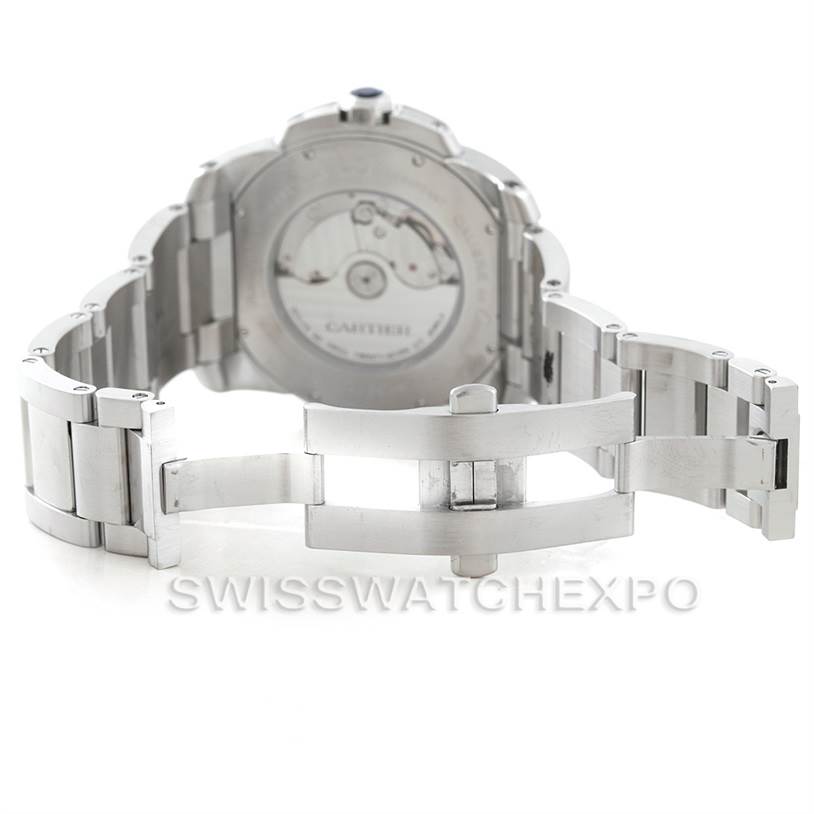 The image shows the back view of a Calibre de Cartier watch by Cartier with its open metal bracelet and visible mechanical movement.