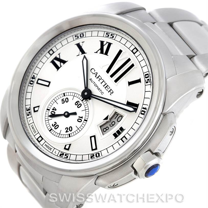 The image shows a Calibre de Cartier watch by Cartier from a three-quarter angle, highlighting the dial, bracelet, and crown.