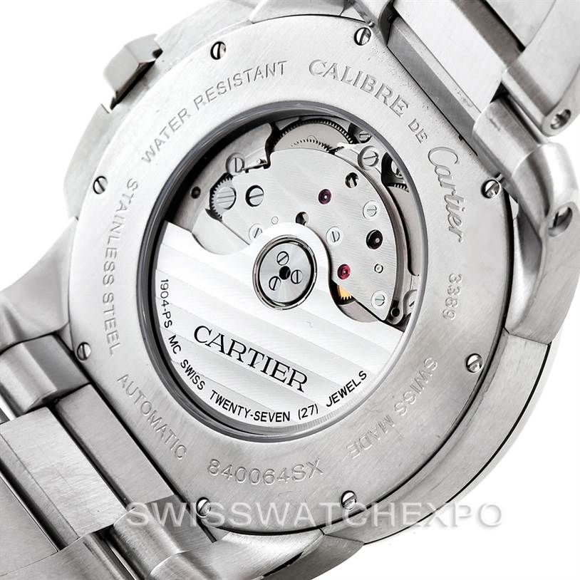 The image shows the back view of a Calibre de Cartier watch by Cartier, highlighting its movement and stainless steel case back.