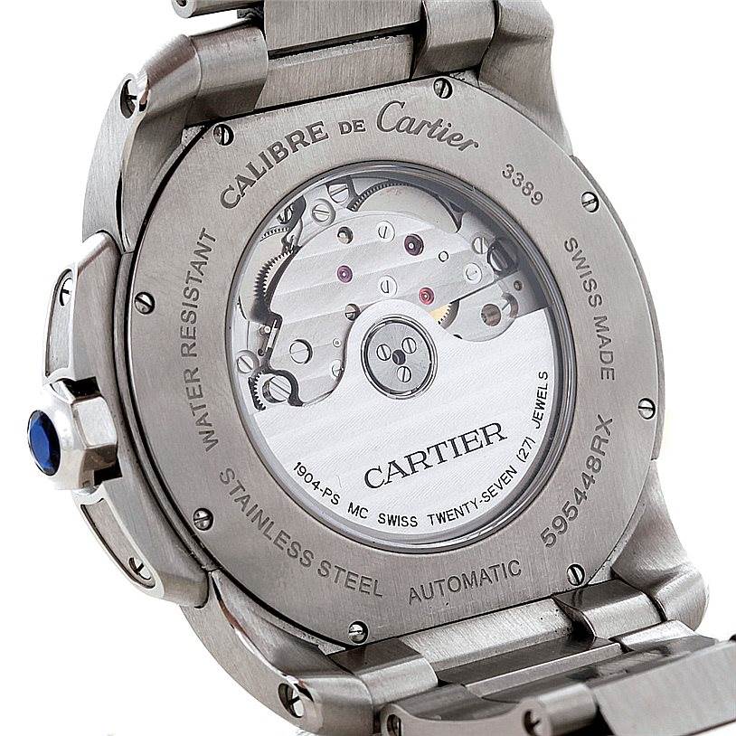 The image shows the back of a Calibre de Cartier watch by Cartier, displaying its automatic movement and stainless steel case.