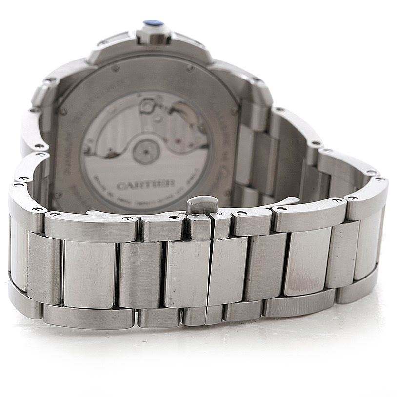 The image shows the back of the Calibre de Cartier watch by Cartier, featuring the movement and the metal bracelet.