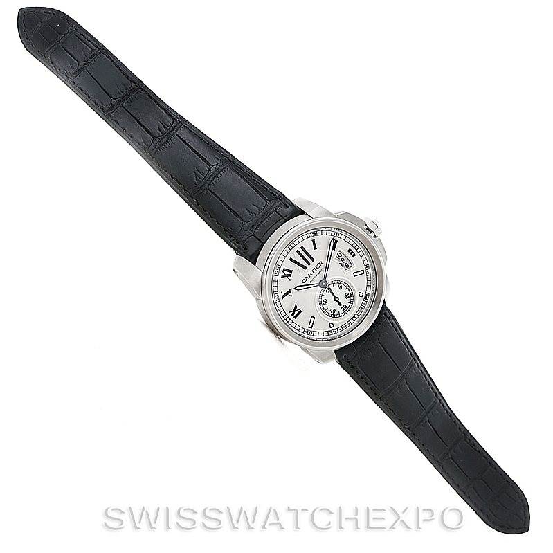 The image shows a top view of a Calibre de Cartier model by Cartier, displaying the watch face, case, and strap.