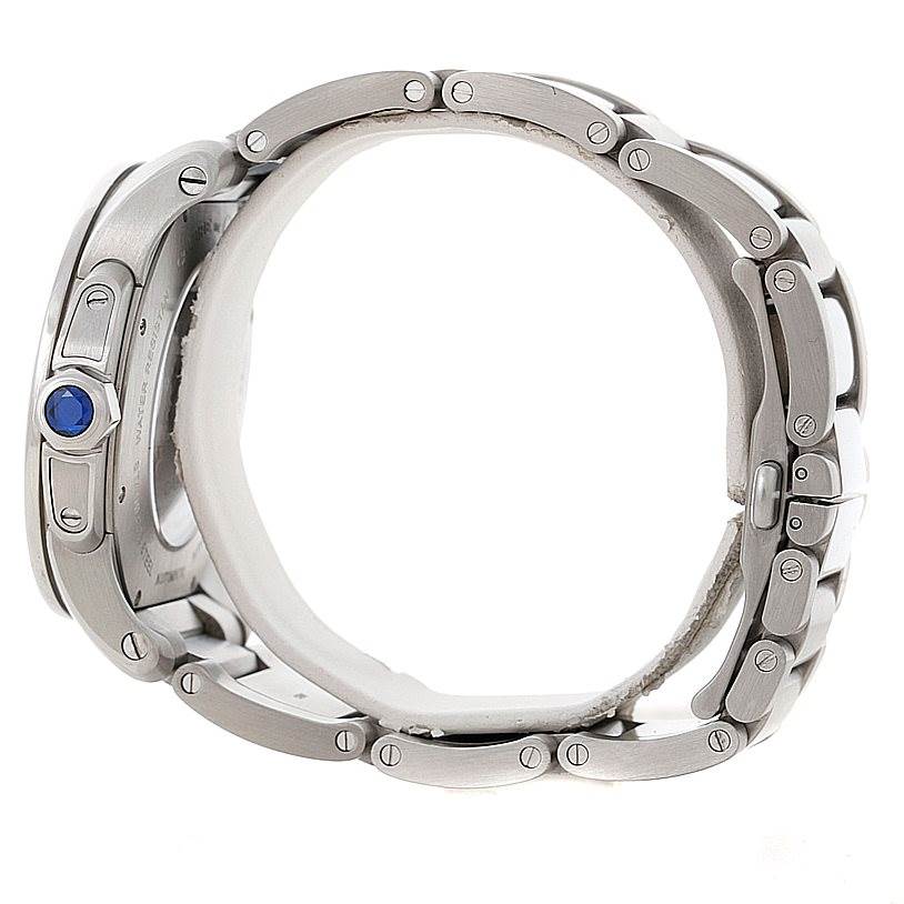 The image shows a side view of the Calibre de Cartier watch by Cartier, focusing on the bracelet links and crown with a blue accent.