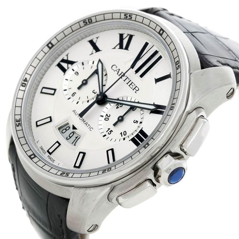 The image shows a close-up, angled view of the face and side of a Calibre de Cartier watch by Cartier, highlighting its chronograph dials and crown.