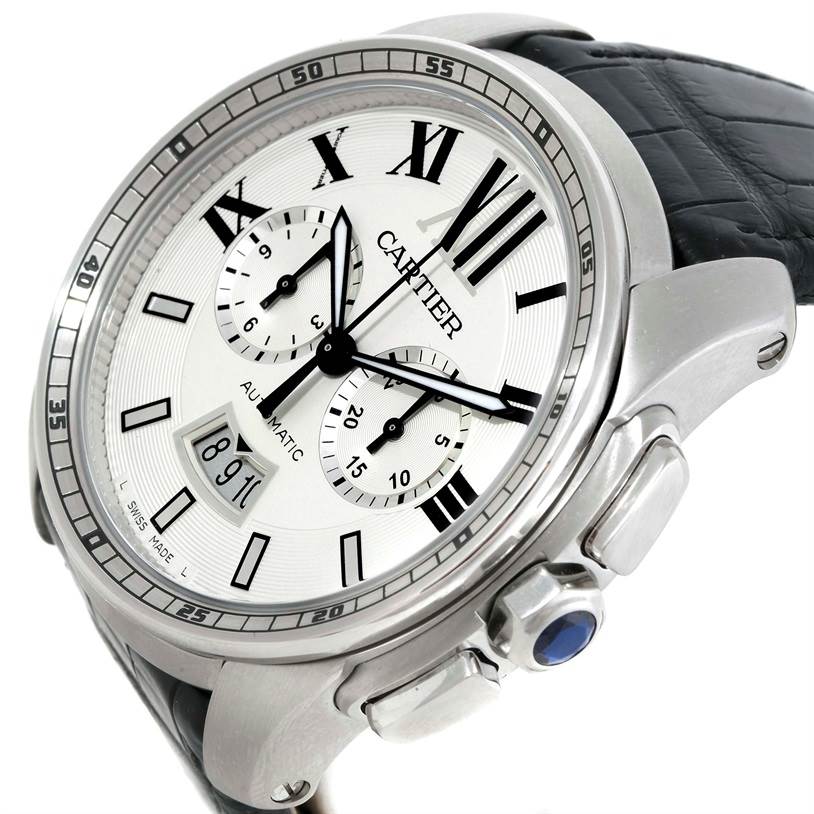 The image shows a Calibre de Cartier watch by Cartier at an angled view, highlighting its face, bezel, and part of the strap.