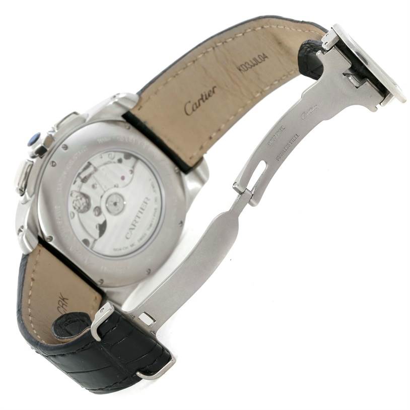 The image shows the back and partially open clasp of a Calibre de Cartier watch by Cartier.