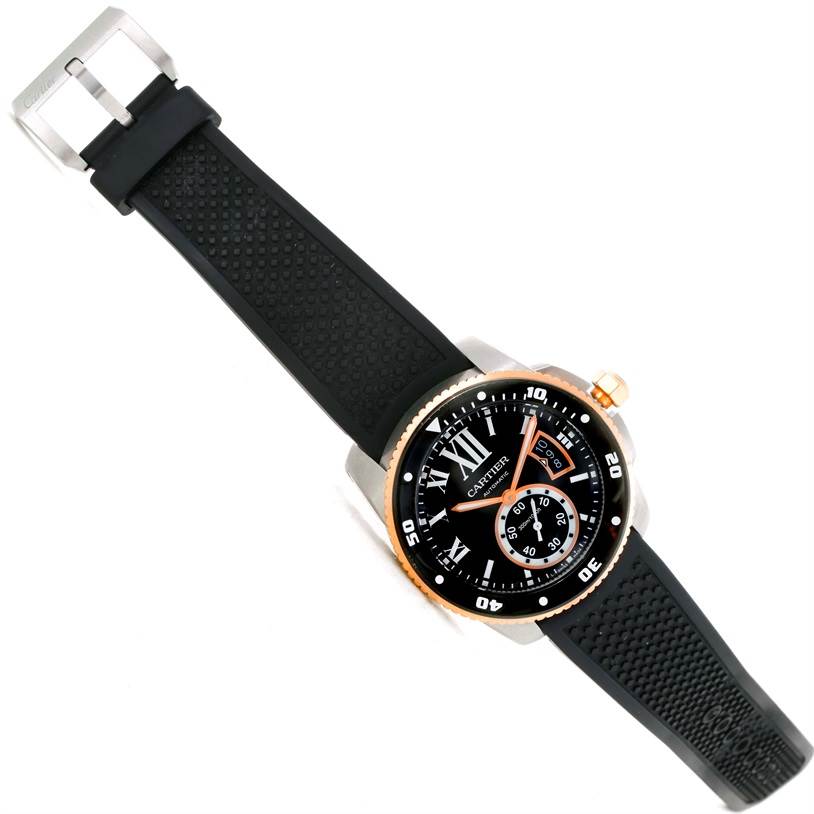 The image shows a Calibre de Cartier watch by Cartier at an angled view, highlighting its black rubber strap, dial, and bezel.