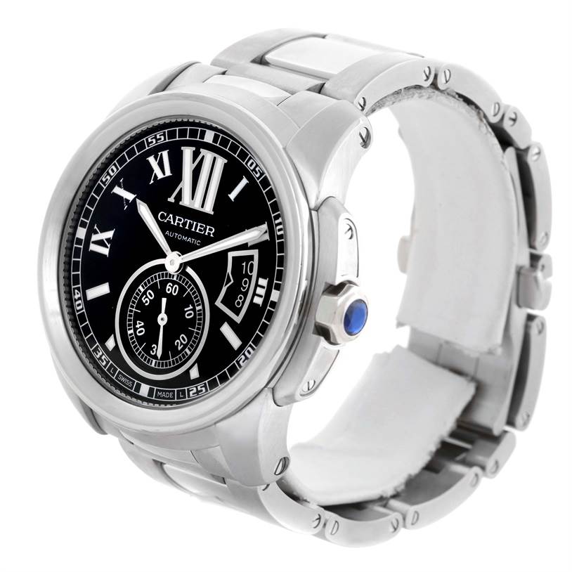 The image shows a Calibre de Cartier watch by Cartier, displaying its face, bezel, crown with a blue cabochon, and metal bracelet at a three-quarter angle.