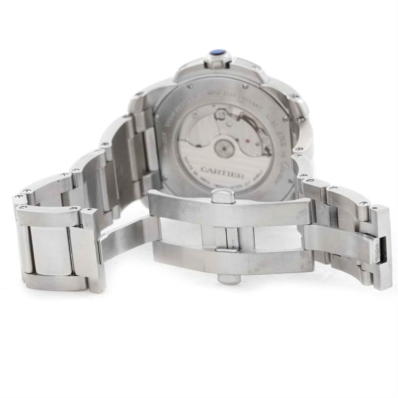 The image shows the back view of a Calibre de Cartier watch by Cartier, highlighting its open stainless steel bracelet and movement.