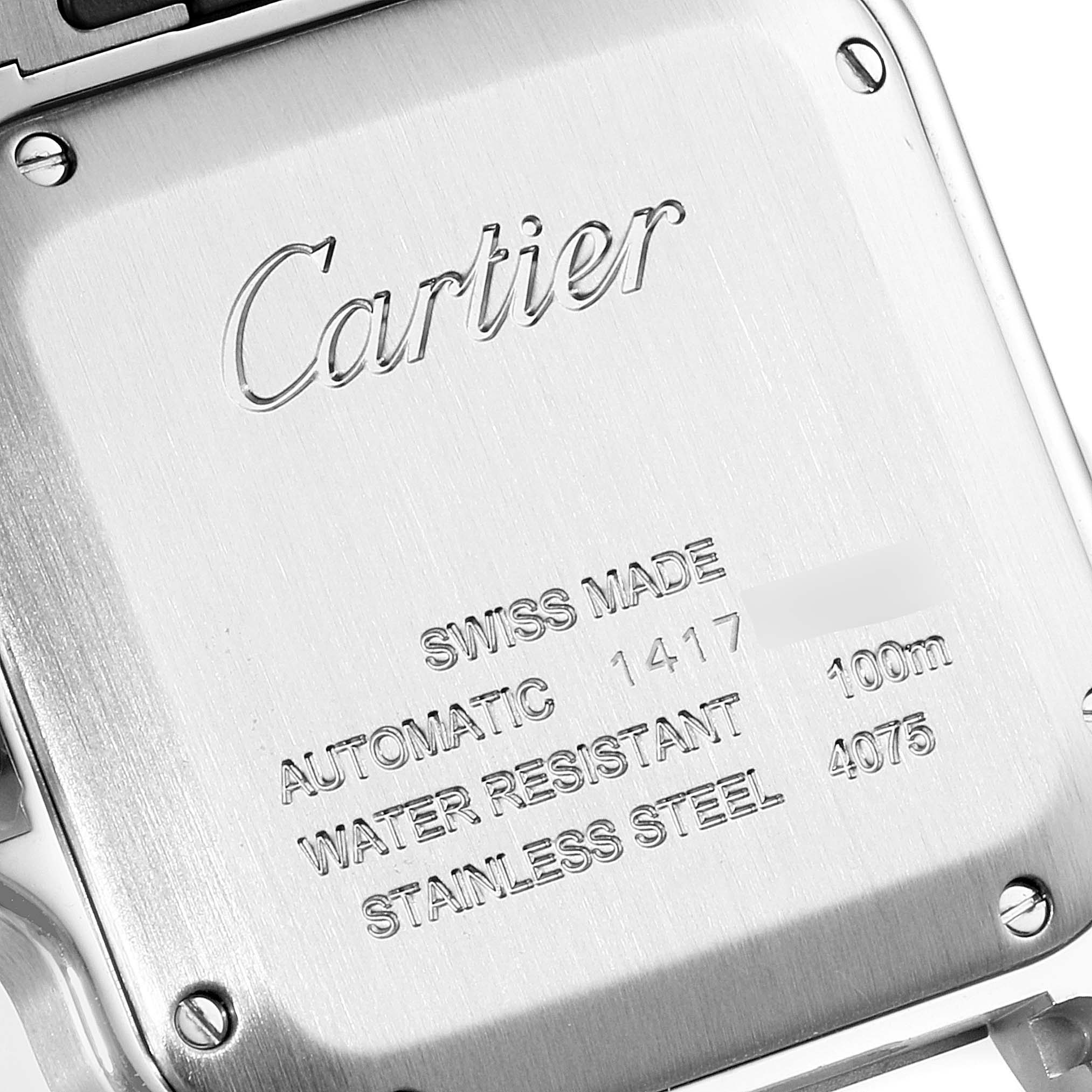 The image shows the case back of a Cartier Santos WSSA0010 Men's Stainless Steel Silver Dial WSSA0010 Men's Stainless Steel Silver Dial watch at an angled close-up view, highlighting its inscriptions and screws.