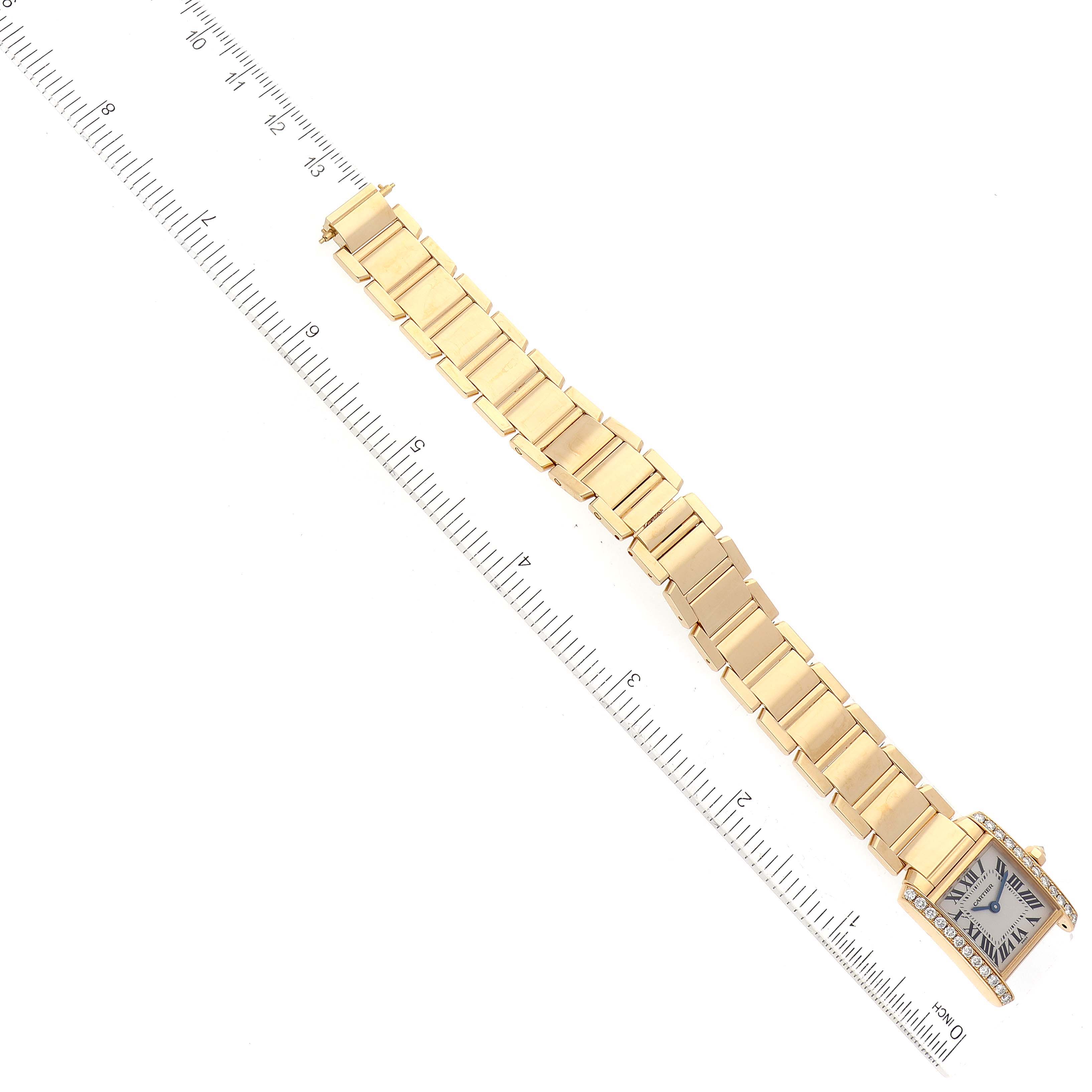 The image shows a top-down view of the Cartier Tank Française watch, including the case and full bracelet, alongside a ruler for scale.