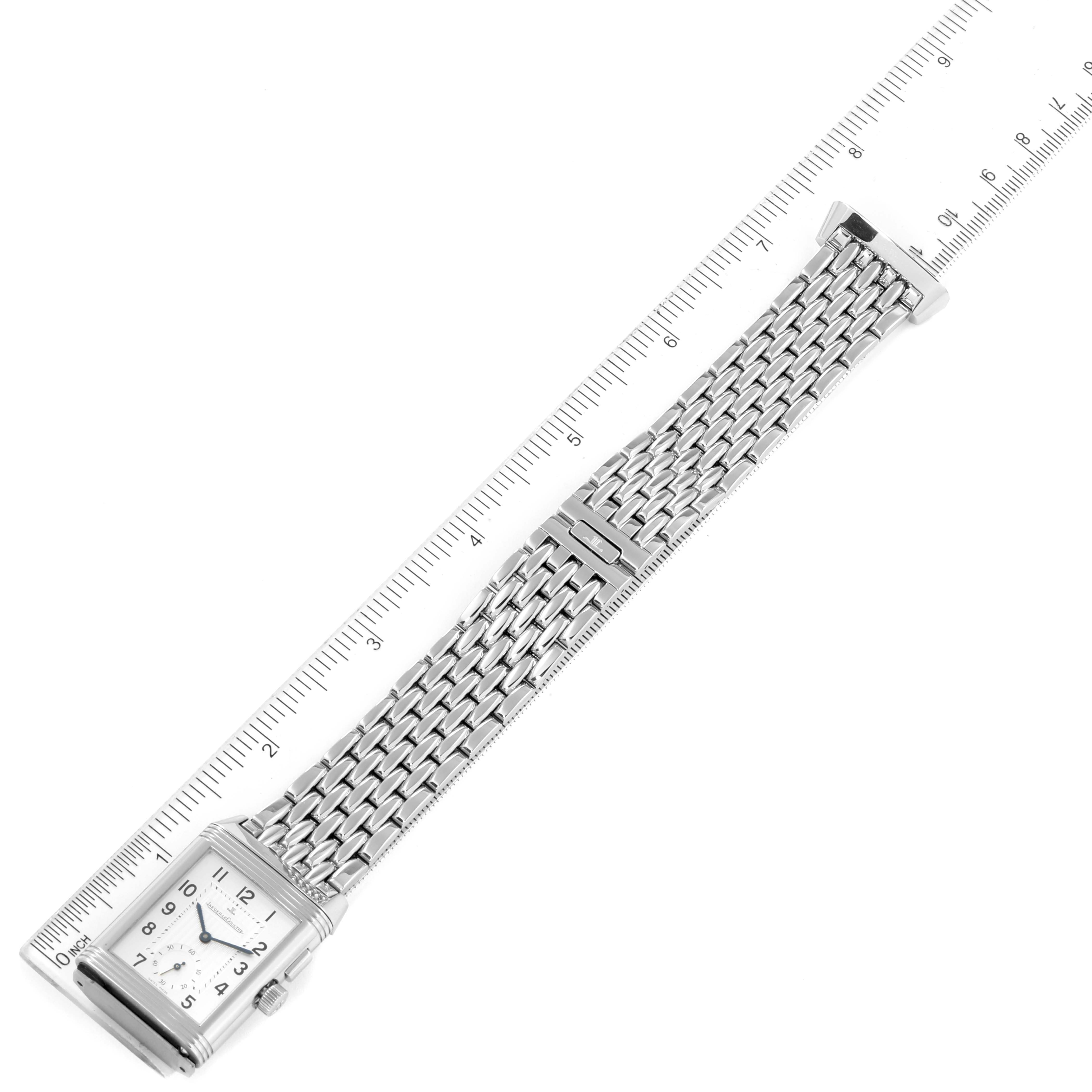 This image shows the Jaeger LeCoultre Reverso Q2718110 Men's Stainless Steel Silver Dial Q2718110 Men's Stainless Steel Silver Dial watch from an overhead angle, displaying the case, dial, and metal bracelet alongside a ruler.