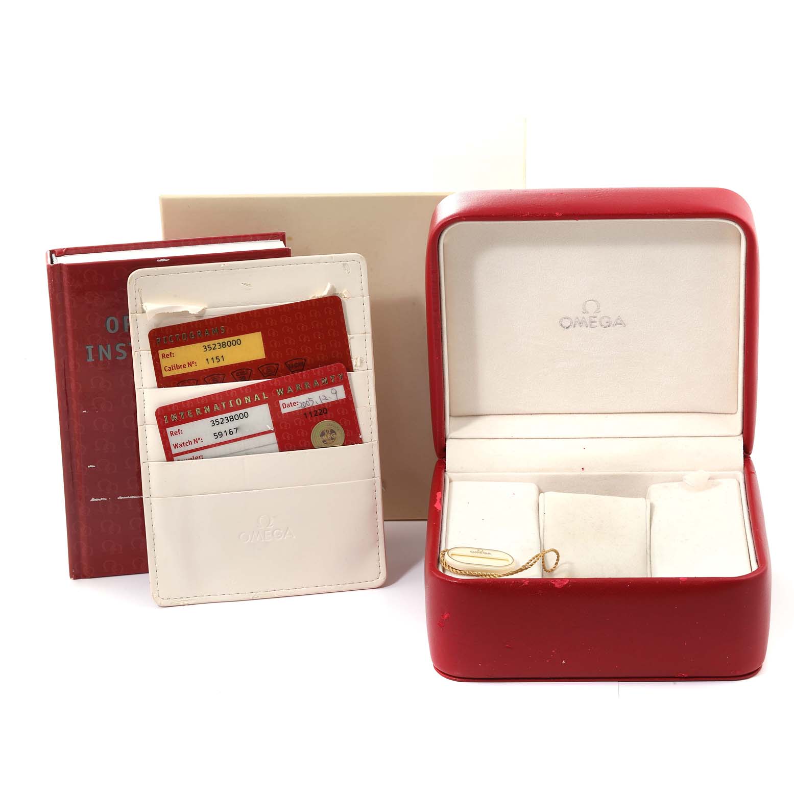 This image shows the accessories of an Omega Speedmaster 3523.80.00 Men
s Stainless Steel Blue Dial 3523.80.00 Men
s Stainless Steel Blue Dial, including a red watch box, instruction manual, and warranty cards.