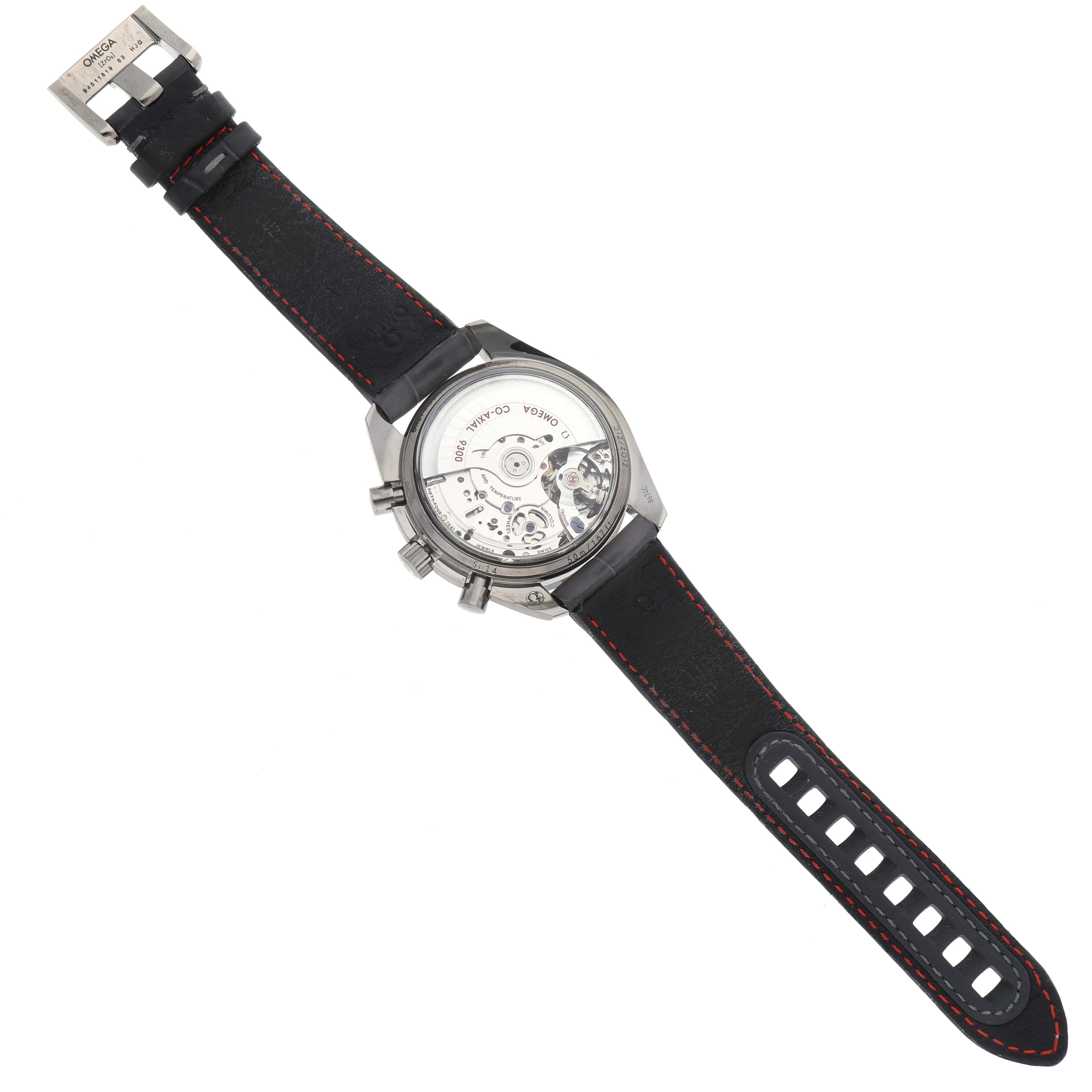 The image shows the back view of the Omega Speedmaster 311.93.44.51.99.001 Men's Ceramic Silver Dial 311.93.44.51.99.001 Men's Ceramic Silver Dial, displaying the watch's movement and its leather strap with red stitching.