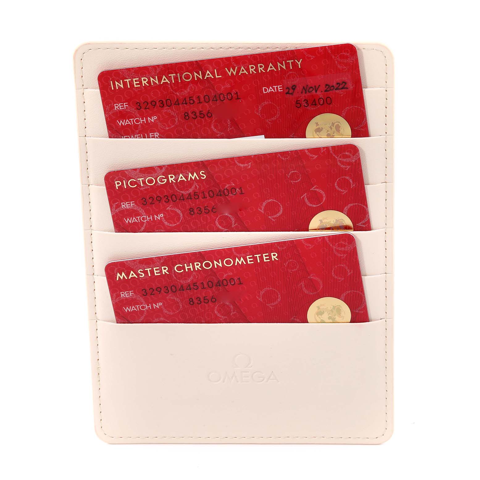 The image shows three Omega Speedmaster 329.30.44.51.04.001 Men
s Stainless Steel White Dial 329.30.44.51.04.001 Men
s Stainless Steel White Dial model warranty and certification cards in a white cardholder at a straight-on angle.