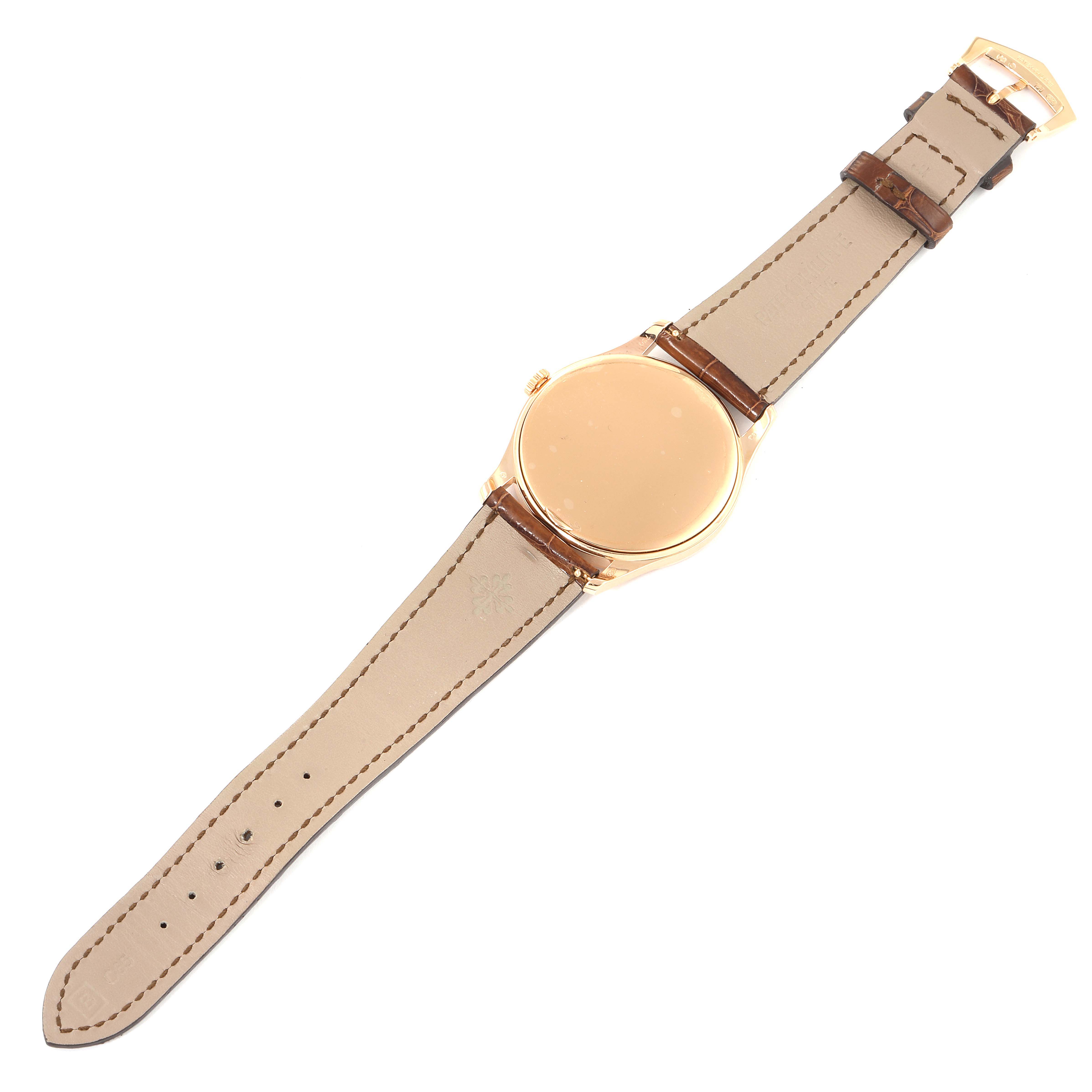 The image shows the back and strap of a Patek Philippe Calatrava 5196R Men
s Rose Gold Silver Dial 5196R Men
s Rose Gold Silver Dial watch from a top-down angle.