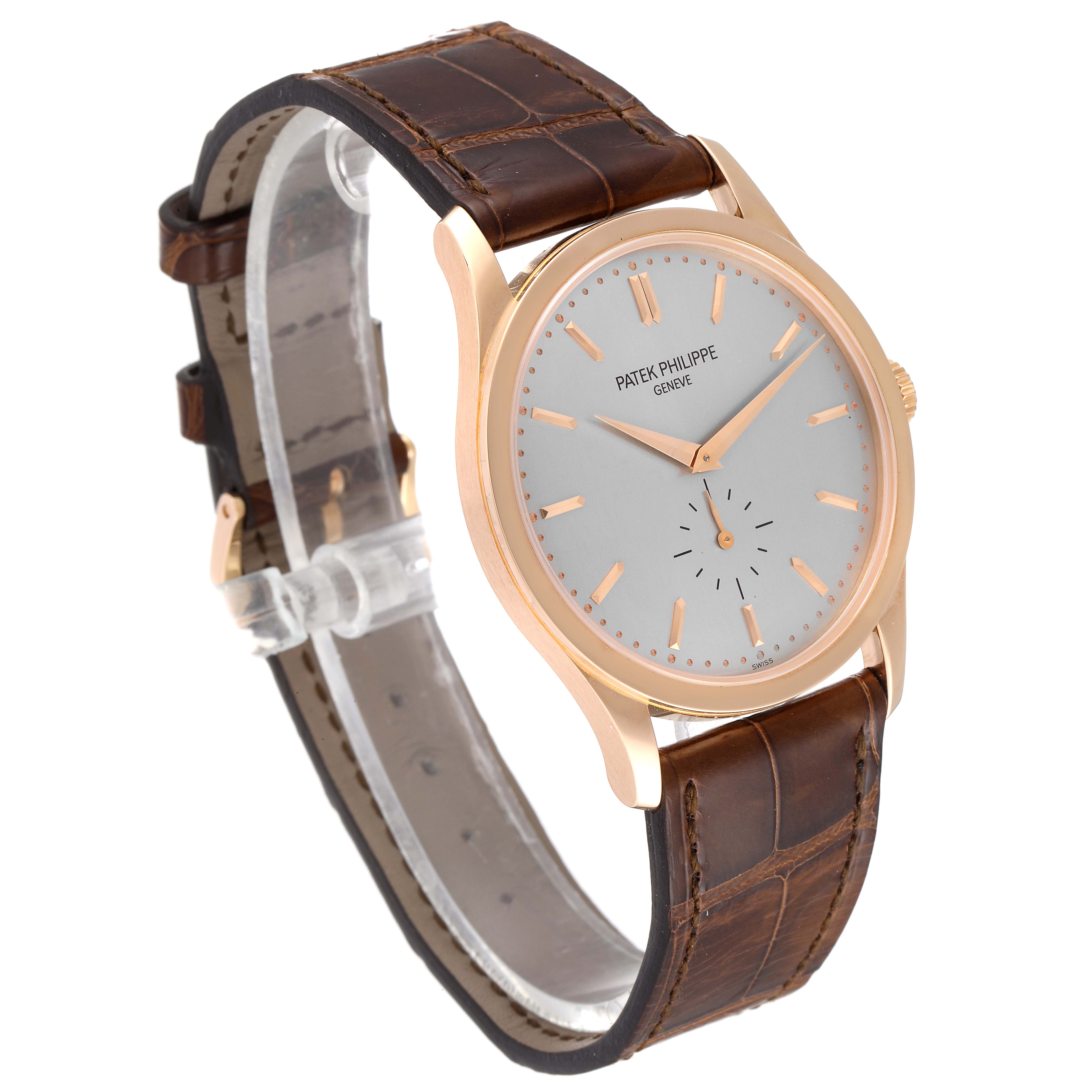 The image shows a Patek Philippe Calatrava 5196R Men
s Rose Gold Silver Dial 5196R Men
s Rose Gold Silver Dial watch angled to display its dial, case, and leather strap.
