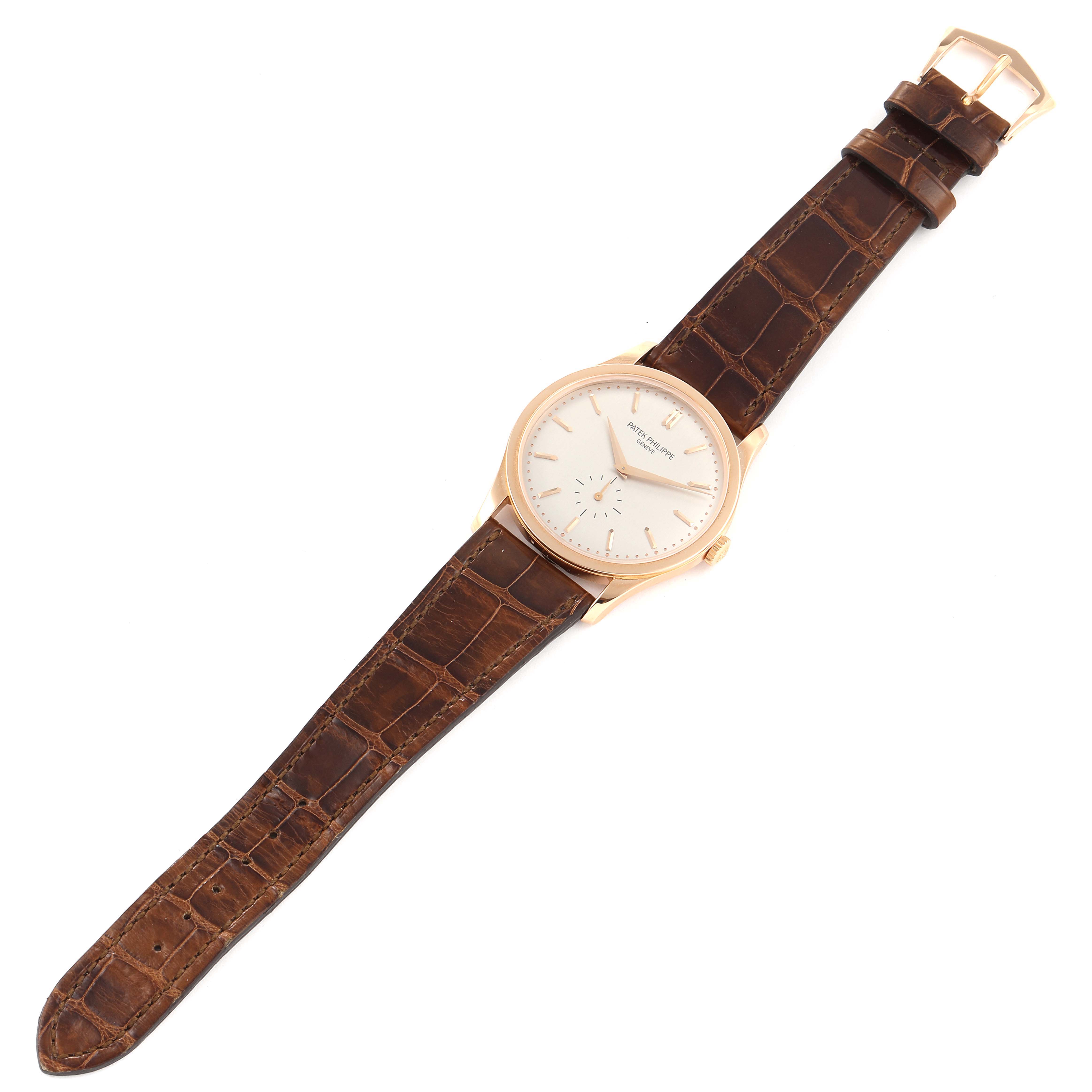 The image shows a Patek Philippe Calatrava 5196R Men
s Rose Gold Silver Dial 5196R Men
s Rose Gold Silver Dial watch at a top-down angle, revealing its face, bezel, case, and brown leather strap.