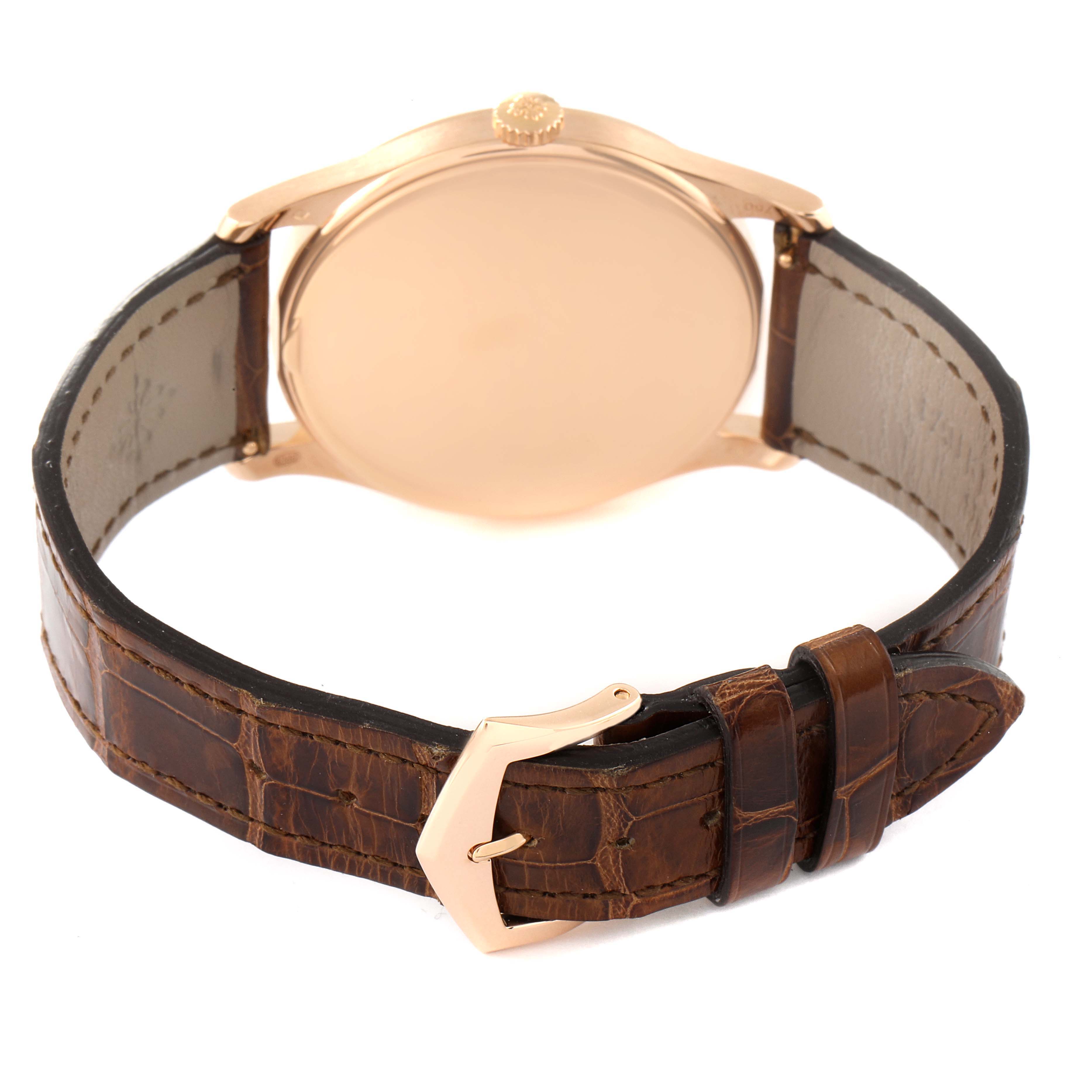 The image shows the back view of a Patek Philippe Calatrava 5196R Men
s Rose Gold Silver Dial 5196R Men
s Rose Gold Silver Dial watch, highlighting the case back, crown, and leather strap with a clasp.