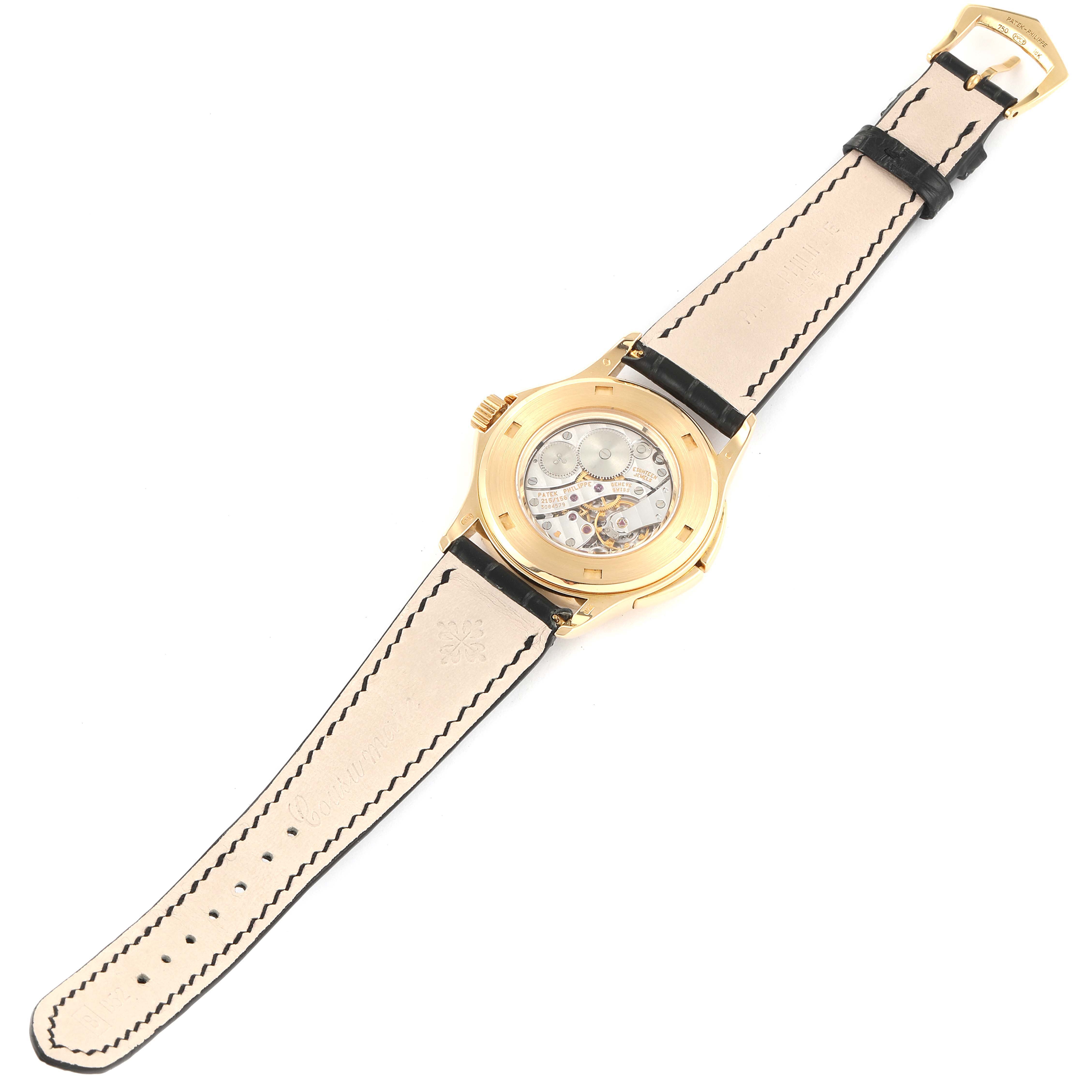 The image shows the back view of a Patek Philippe Calatrava 5134J Men's Yellow Gold White Dial 5134J Men's Yellow Gold White Dial watch with a focus on the movement and leather strap.