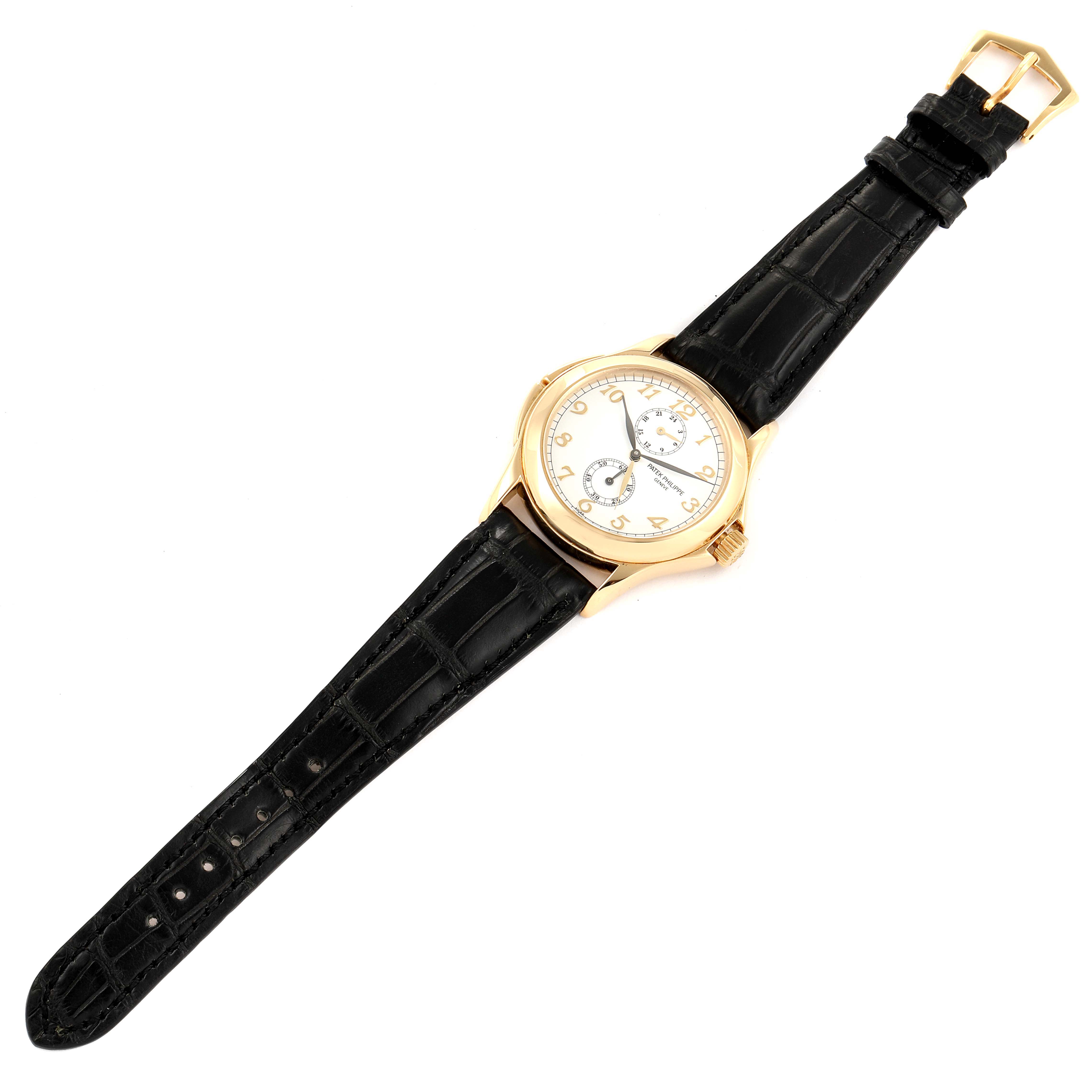 The image shows a top-down view of a Patek Philippe Calatrava 5134J Men's Yellow Gold White Dial 5134J Men's Yellow Gold White Dial watch with a black leather strap and a gold case.