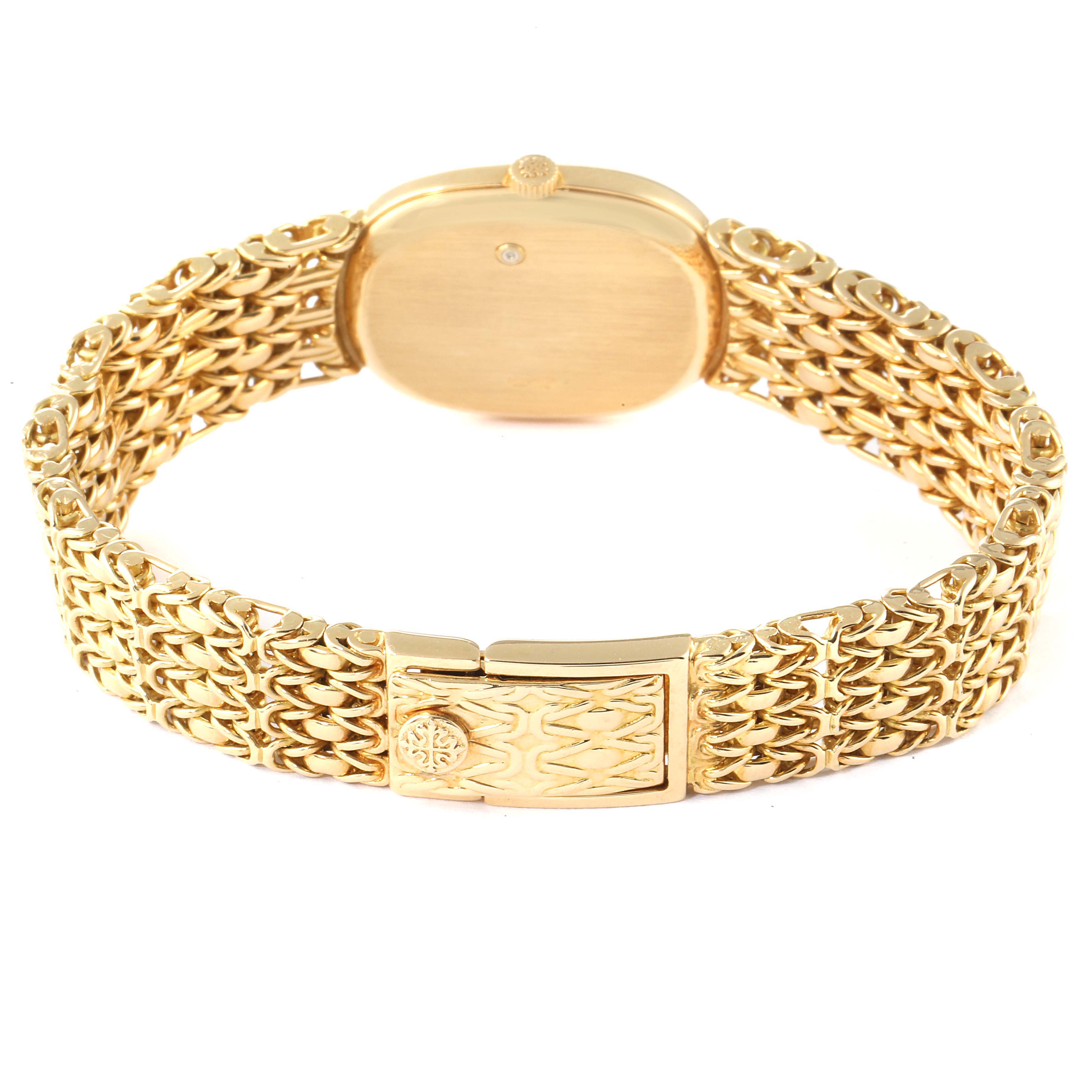The image shows the back of the Patek Philippe Golden Ellipse 4764 Women's Yellow Gold Blue Dial 4764 Women's Yellow Gold Blue Dial watch and its gold bracelet with a clasp.