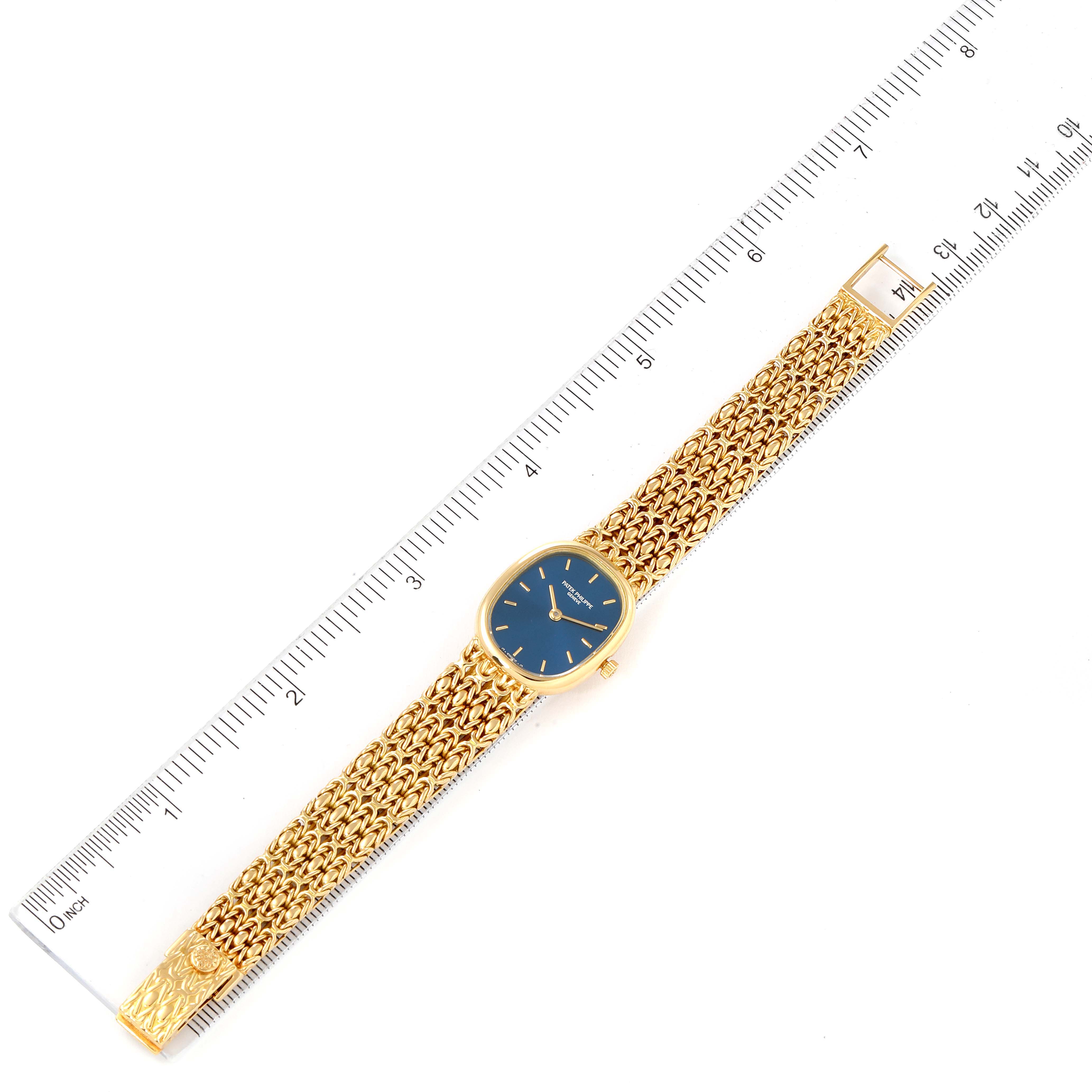 The Patek Philippe Golden Ellipse 4764 Women's Yellow Gold Blue Dial 4764 Women's Yellow Gold Blue Dial watch is shown from a top-down angle with a ruler measuring its length.