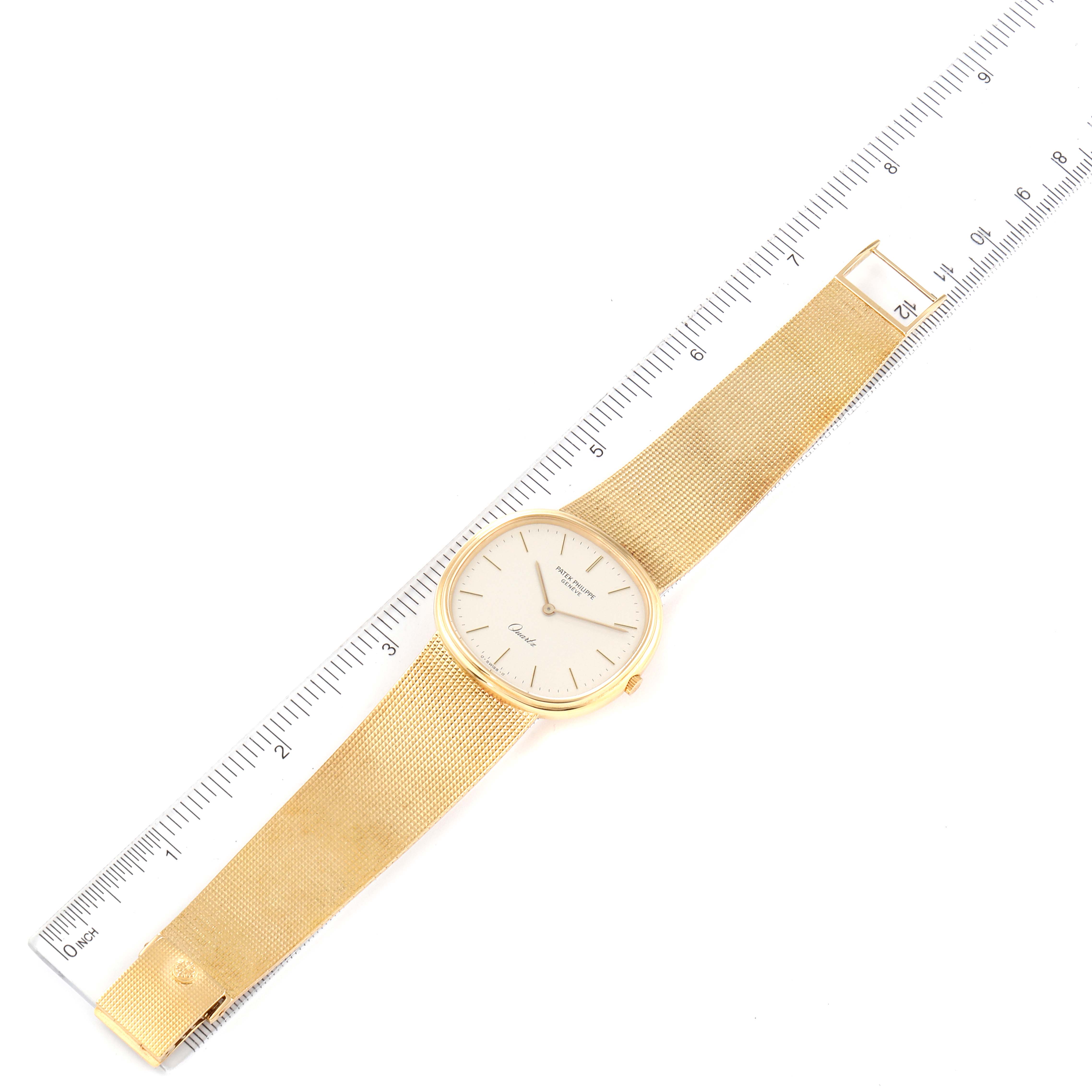 This image shows a top-down view of the Patek Philippe Golden Ellipse 3879 Men's Yellow Gold Silver Dial 3879 Men's Yellow Gold Silver Dial watch, also including a ruler for scale.