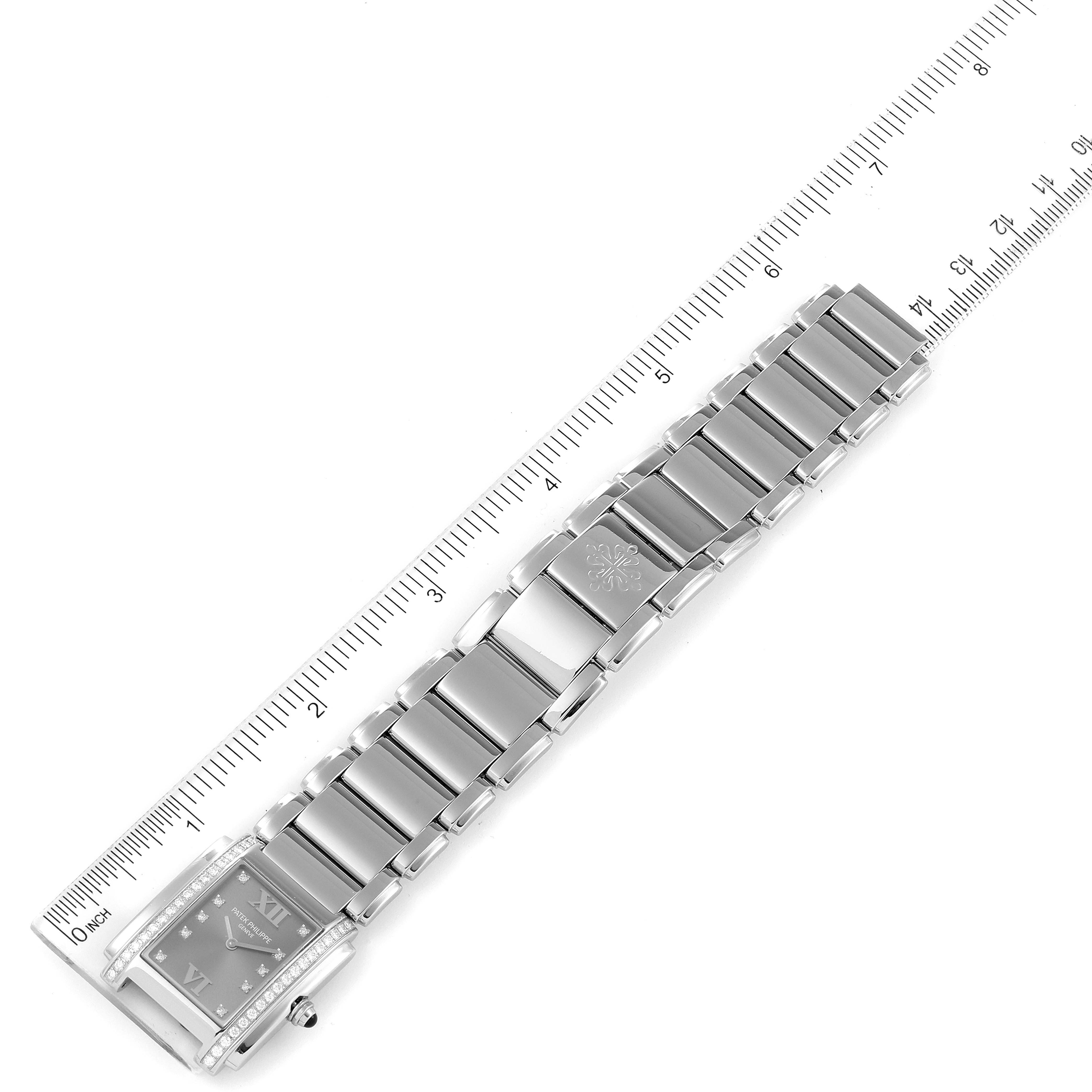 The image shows the Patek Philippe Twenty-4 4910/10A-010 Women's Stainless Steel Grey Dial 4910/10A-010 Women's Stainless Steel Grey Dial watch from a top-down view, highlighting the bracelet and some of the face details with a measuring ruler beside it.