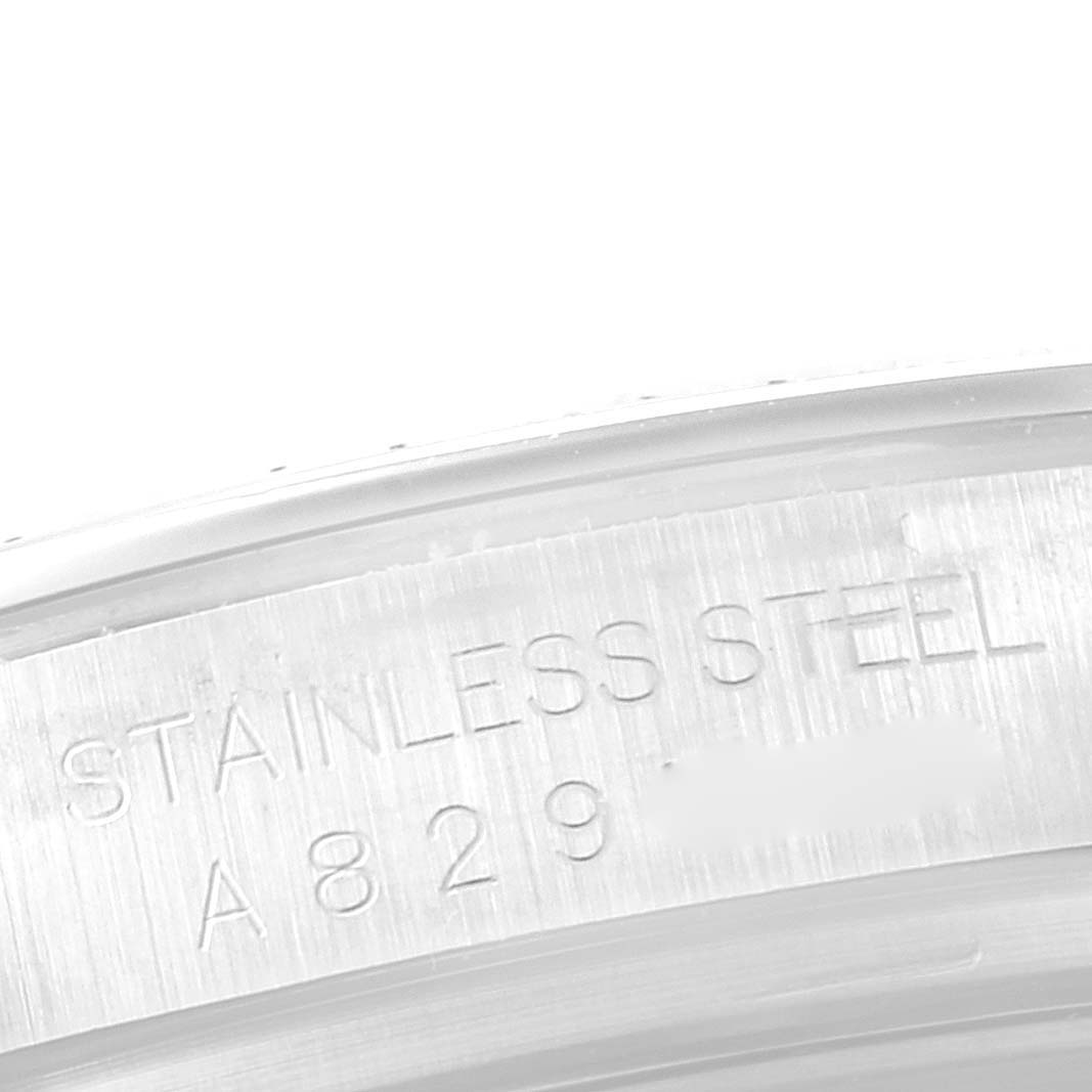 The image shows a close-up of the serial number and "STAINLESS STEEL" engraving inside the bezel of a Rolex Daytona 16520 Men's Stainless Steel Black Dial 16520 Men's Stainless Steel Black Dial watch.