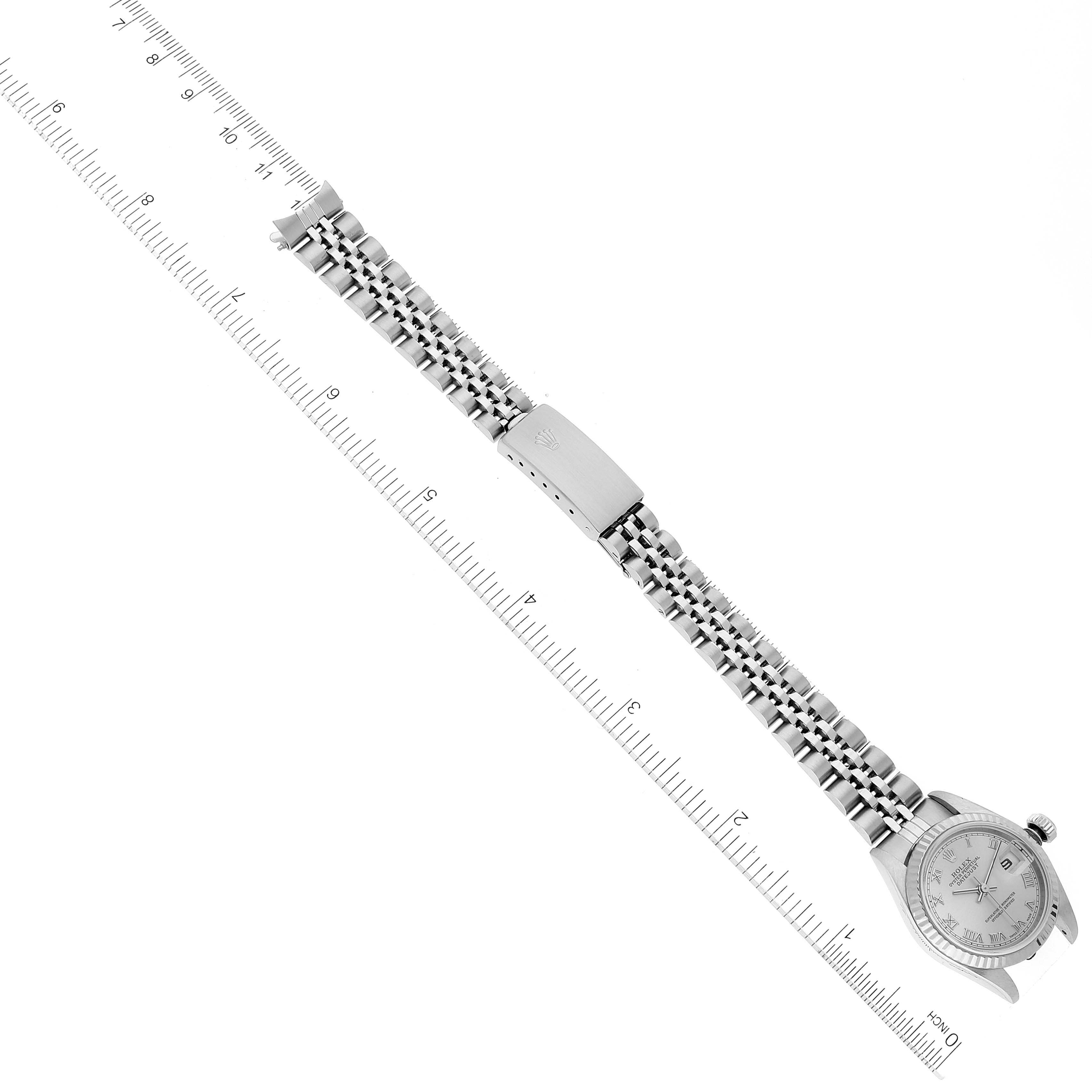 This image shows a Rolex Datejust 79174 Women's Stainless Steel Silver Dial 79174 Women's Stainless Steel Silver Dial watch laid flat with a full view of the bracelet and clasp, alongside a measuring ruler.