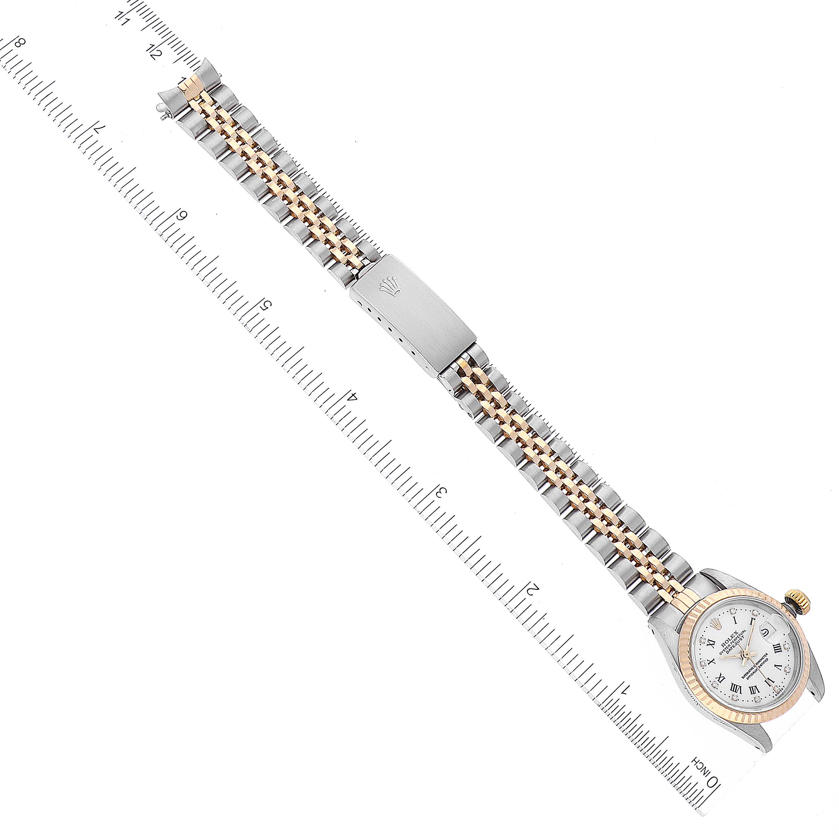 The image shows a Rolex Datejust 69173 Women's Steel and Gold (two tone) White Dial 69173 Women's Steel and Gold (two tone) White Dial model watch laid flat, displaying the face, bezel, and two-tone bracelet with a ruler for scale.