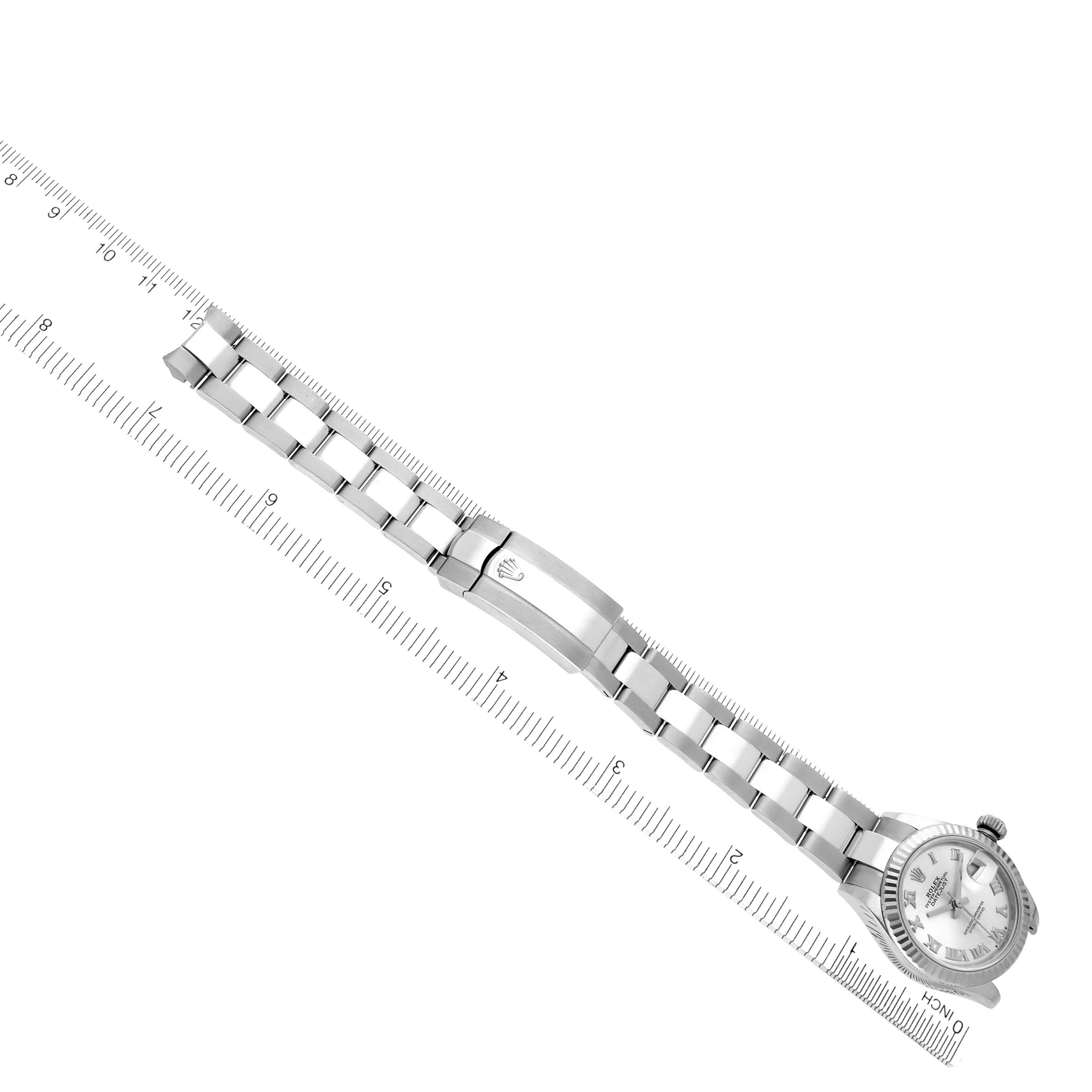 The Rolex Datejust 279174 Women's Stainless Steel Silver Dial 279174 Women's Stainless Steel Silver Dial watch is shown from a top-down angle, displaying the bracelet, clasp, and part of the face aligned with a ruler.