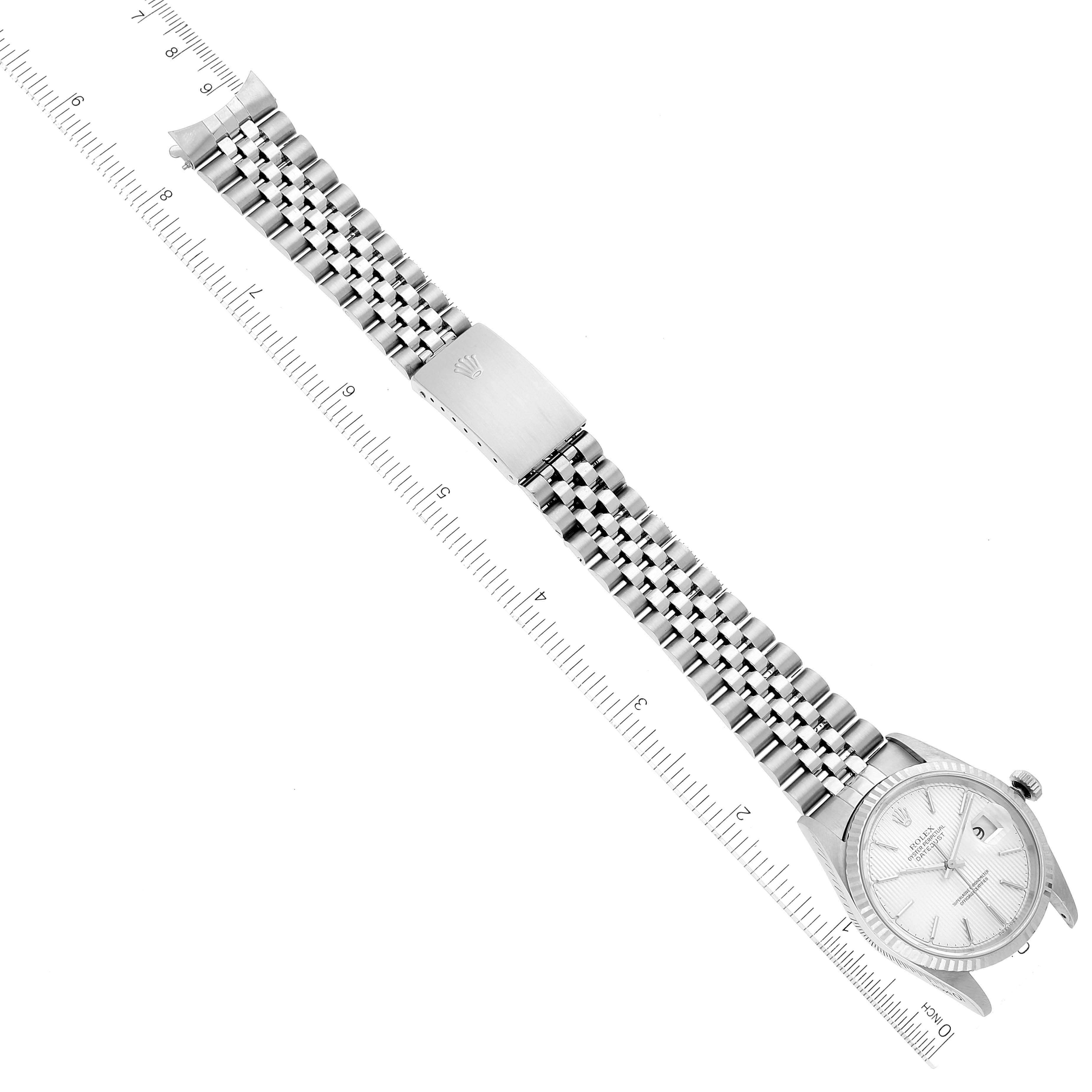 The image shows an overhead view of a Rolex Datejust 16234 Men's Stainless Steel Silver Dial 16234 Men's Stainless Steel Silver Dial watch with a metal bracelet and clasp, placed next to a ruler for scale.