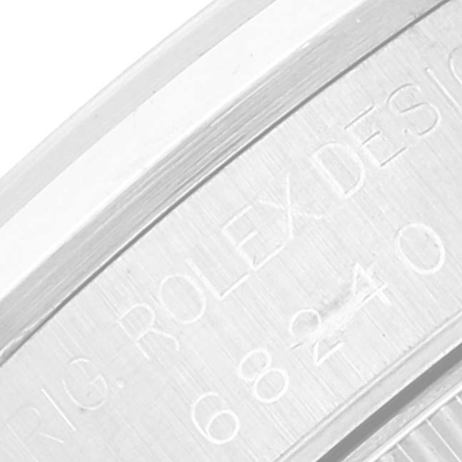 This close-up image of the Rolex Mid-Size 68240 Women
s Stainless Steel Blue Dial 68240 Women
s Stainless Steel Blue Dial watch showcases the engraved design details on its casing.