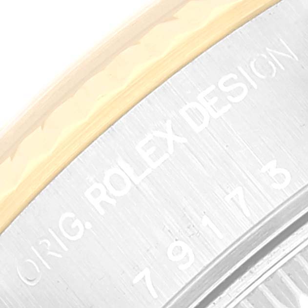 This close-up image of a Rolex Datejust 79173 Women's Steel and Gold (two tone) Champagne Dial 79173 Women's Steel and Gold (two tone) Champagne Dial watch shows the engraving on the side of its case, highlighting "ROLEX DESIGN" and part of the serial number.