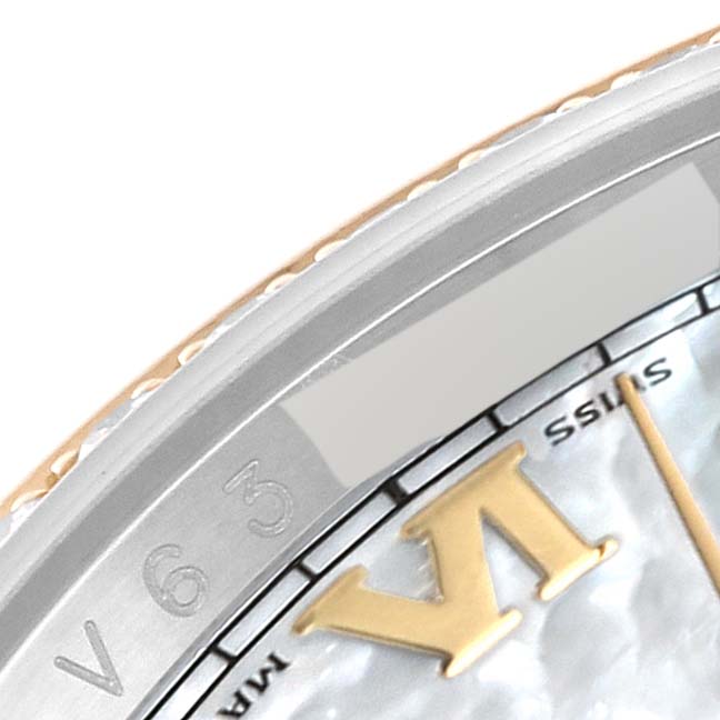 The image shows a close-up of the bezel and part of the dial of a Rolex Datejust 116243 Men's Steel and Gold (two tone) Mother of Pearl Dial 116243 Men's Steel and Gold (two tone) Mother of Pearl Dial watch, focusing on the Roman numeral VI and minor text.