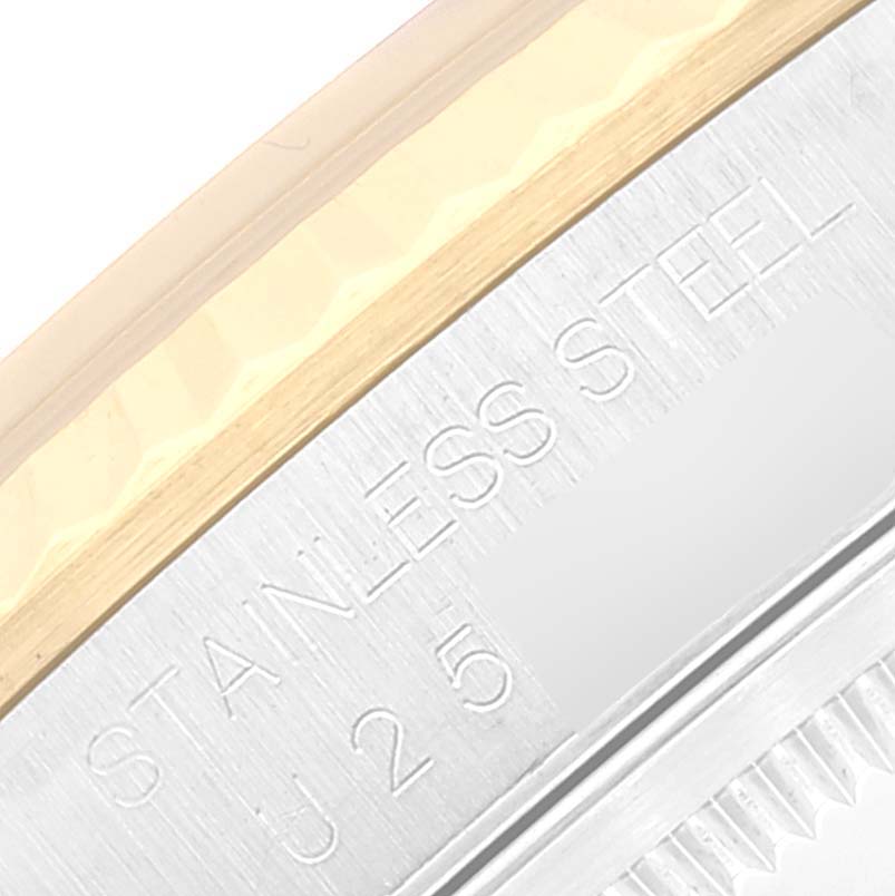 This close-up image shows the Rolex Datejust 16233 Men's Steel and Gold (two tone) Silver Dial 16233 Men's Steel and Gold (two tone) Silver Dial's stainless steel and gold bezel with some engraved text.