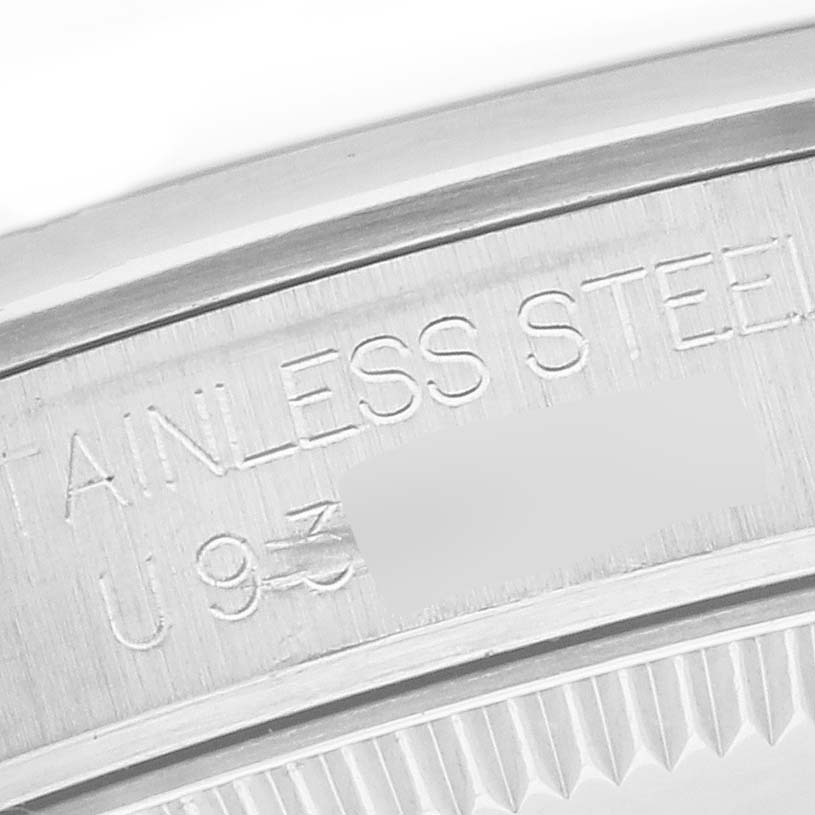 The image shows a close-up of the outer edge of a Rolex Mid-Size 67480 Women's Stainless Steel Silver Dial 67480 Women's Stainless Steel Silver Dial watch, highlighting the engraved "STAINLESS STEEL" text and part of the case.