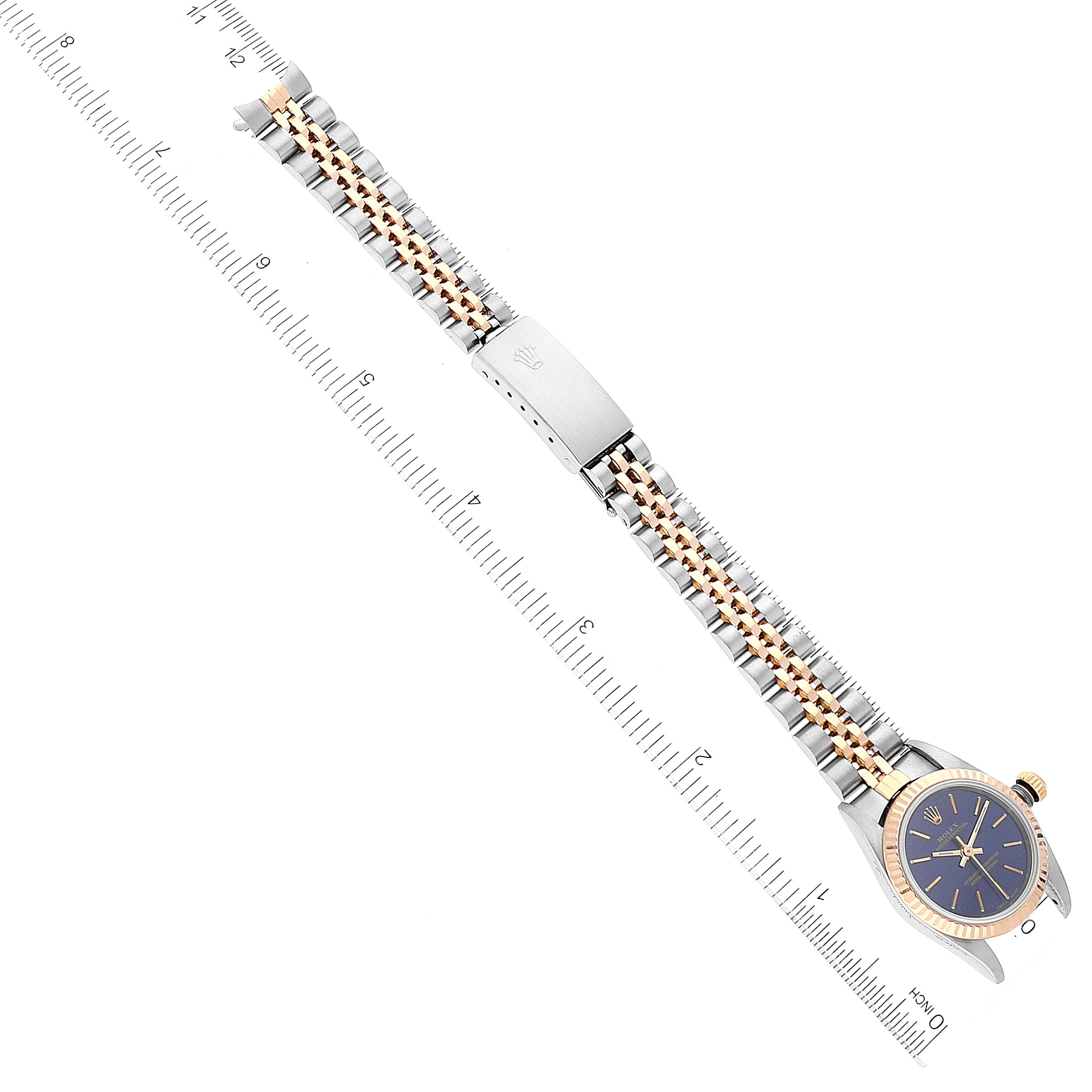 This image shows a top-down view of a Rolex Oyster Perpetual 76193 Women
s Steel and Gold (two tone) Blue Dial 76193 Women
s Steel and Gold (two tone) Blue Dial watch, featuring the face, bezel, and bracelet with a ruler for scale.