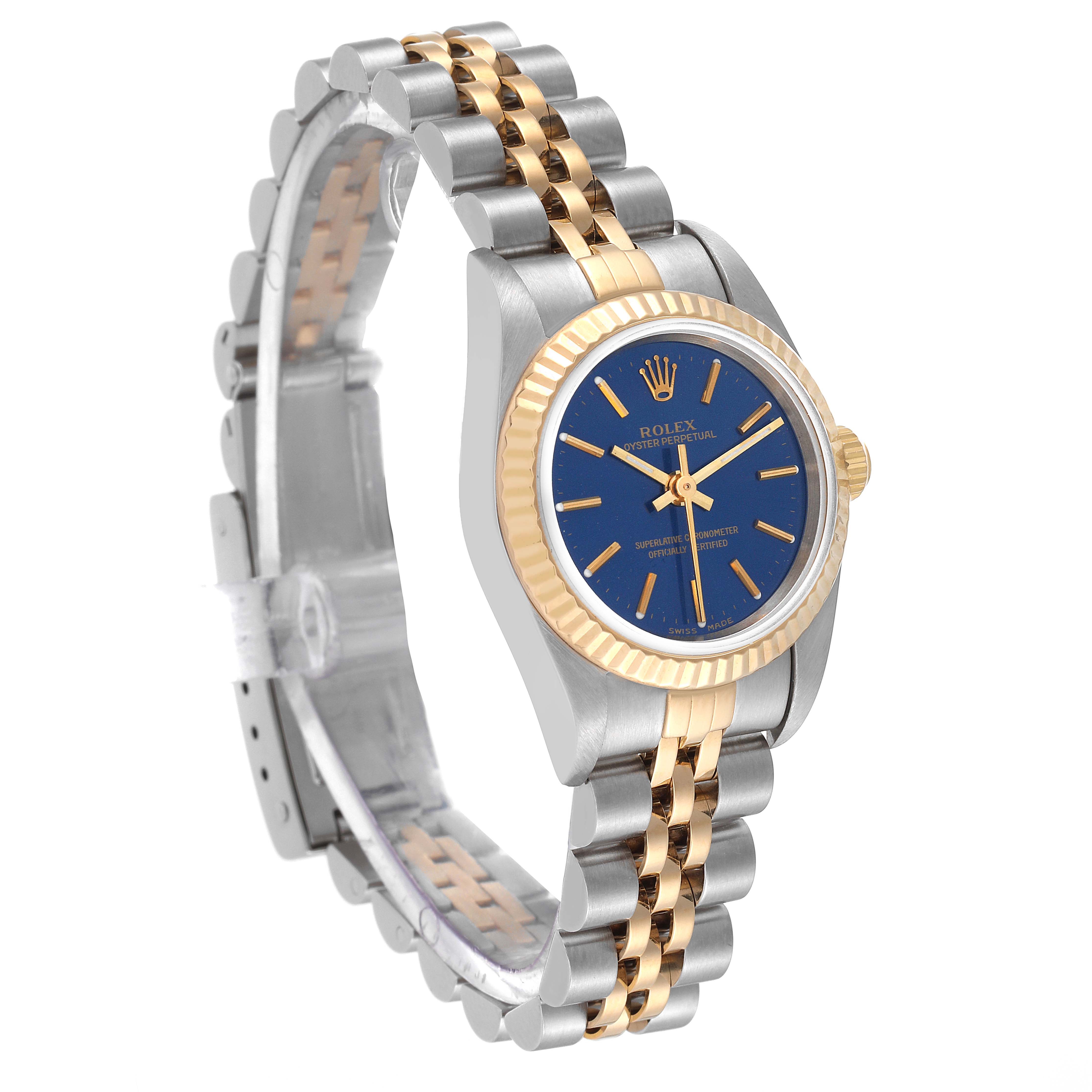 The Rolex Oyster Perpetual 76193 Women
s Steel and Gold (two tone) Blue Dial 76193 Women
s Steel and Gold (two tone) Blue Dial watch is shown at a three-quarter angle, highlighting the blue dial, two-tone bracelet, and fluted bezel.