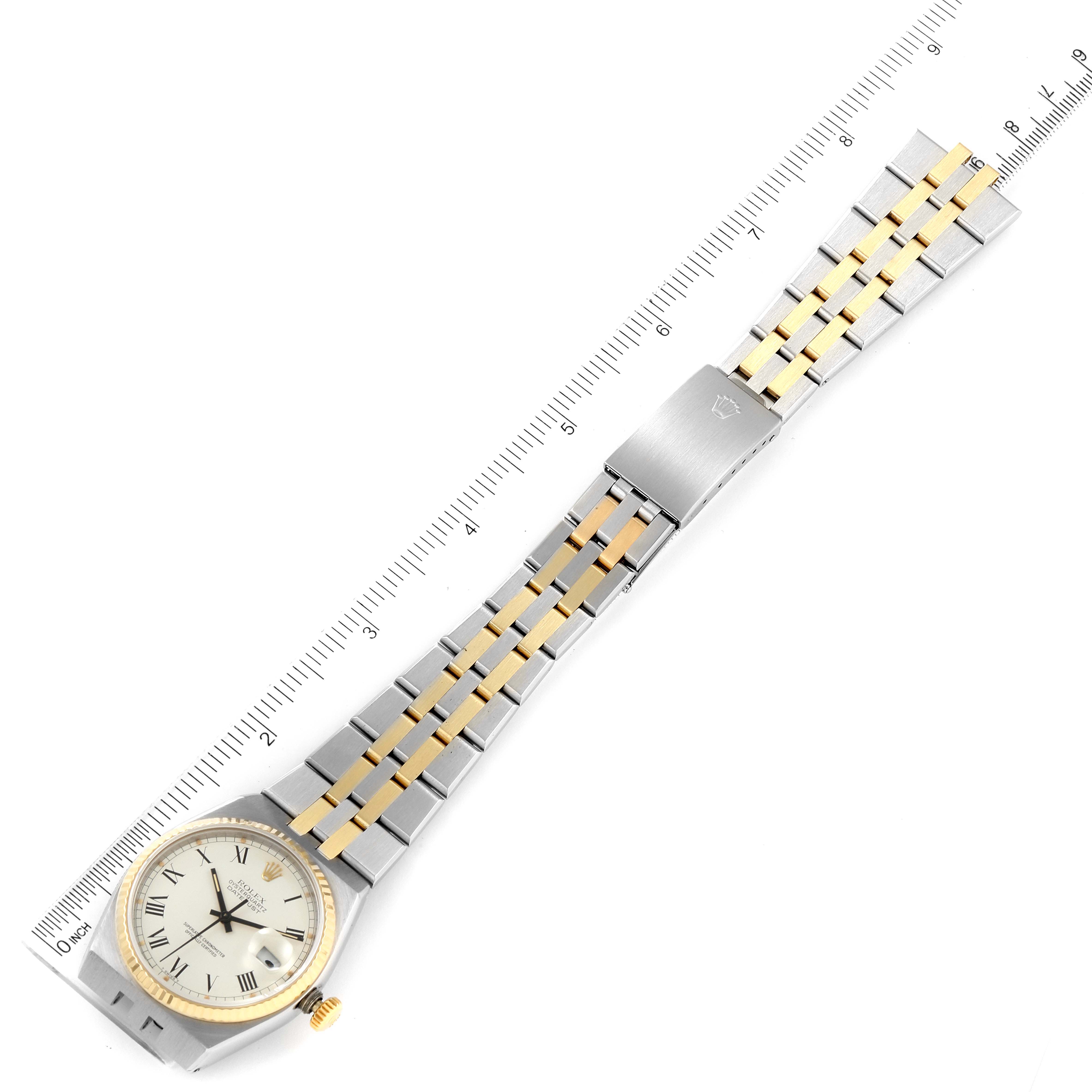 The image shows a top view of a Rolex Oysterquartz 17013 Men's Steel and Gold (two tone) White Dial 17013 Men's Steel and Gold (two tone) White Dial watch with its bracelet fully extended and a ruler for scale.