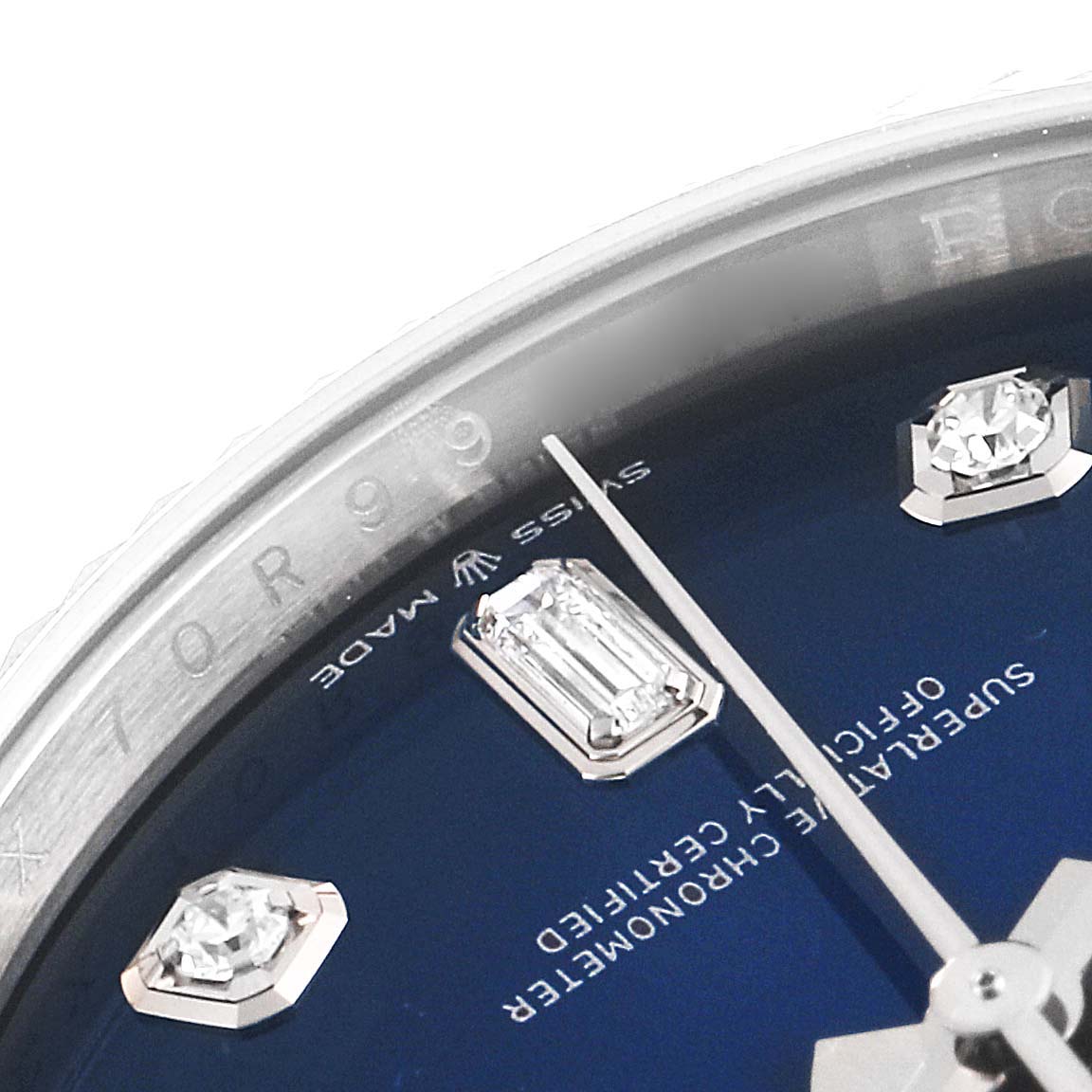 This close-up image of a Rolex President 128239 Men's White Gold Blue Dial 128239 Men's White Gold Blue Dial watch shows the dial with diamond hour markers and part of the bezel with engraving.