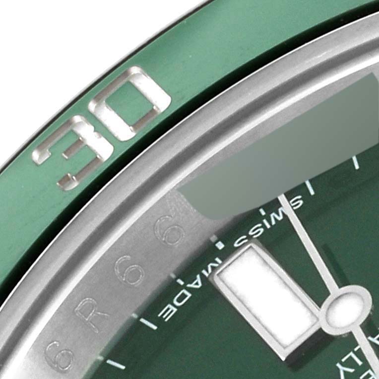 This image shows a close-up angle of a Rolex Submariner 116610LV Men's Stainless Steel Green Dial 116610LV Men's Stainless Steel Green Dial watch, highlighting part of its bezel, dial, and one of the hands.