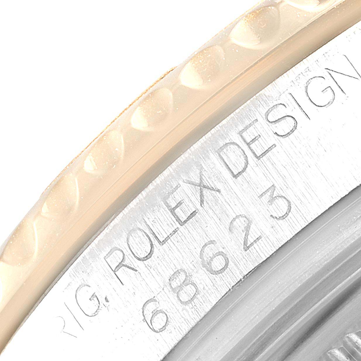 This close-up image of the Rolex Yacht-Master 168623 Men's Steel and Gold (two tone) Grey Dial 168623 Men's Steel and Gold (two tone) Grey Dial model shows part of the bezel and the engraved serial number on the case.